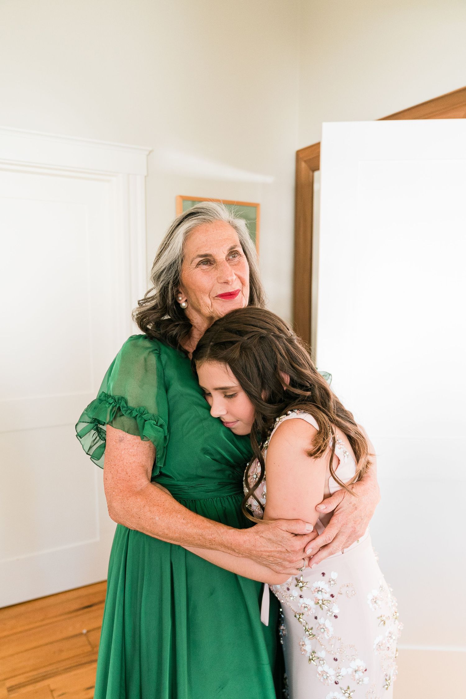 a grandmother lovingly holds her grand daughter in a candid moment
