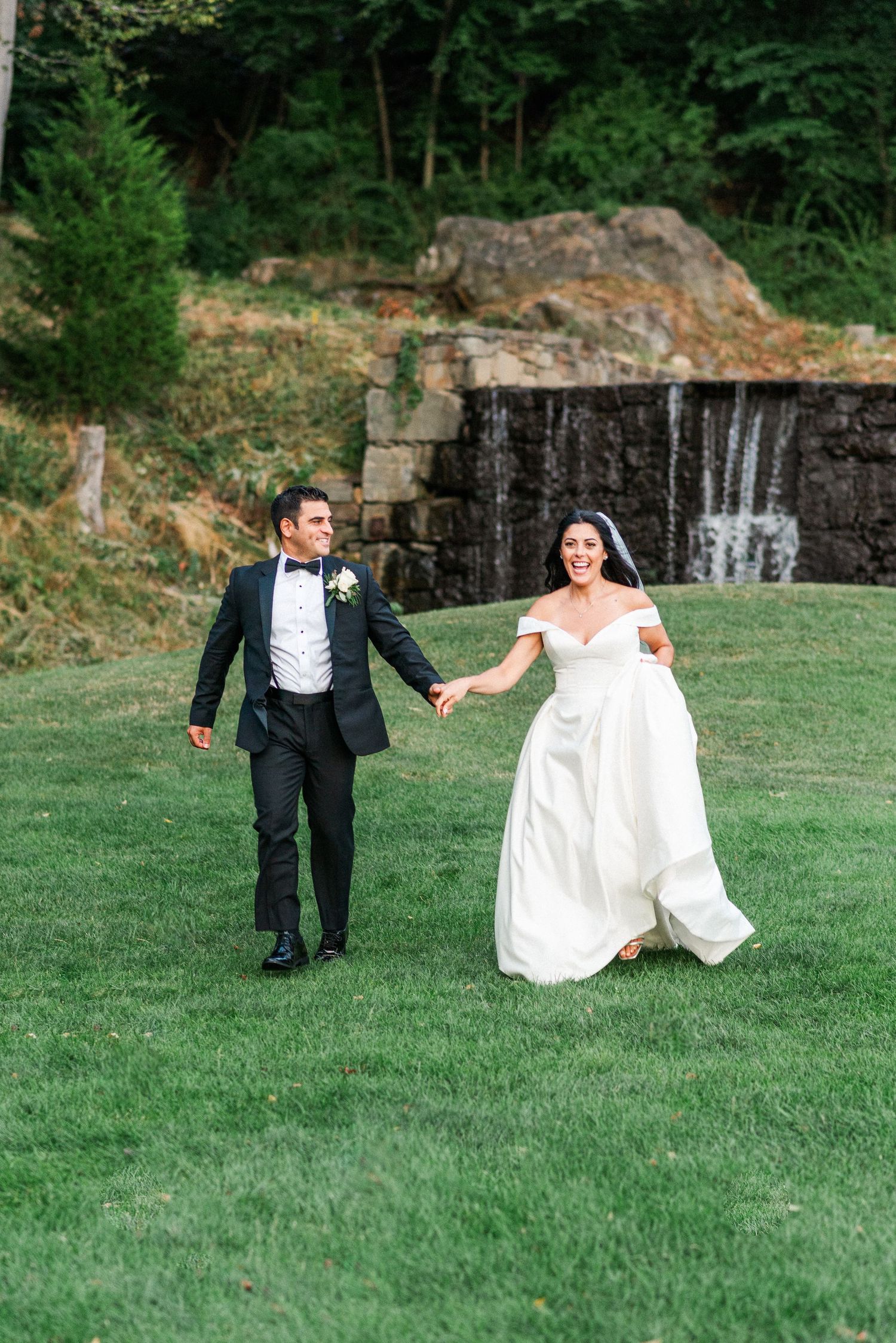 Bride and groom running on a golf course for their wedding.