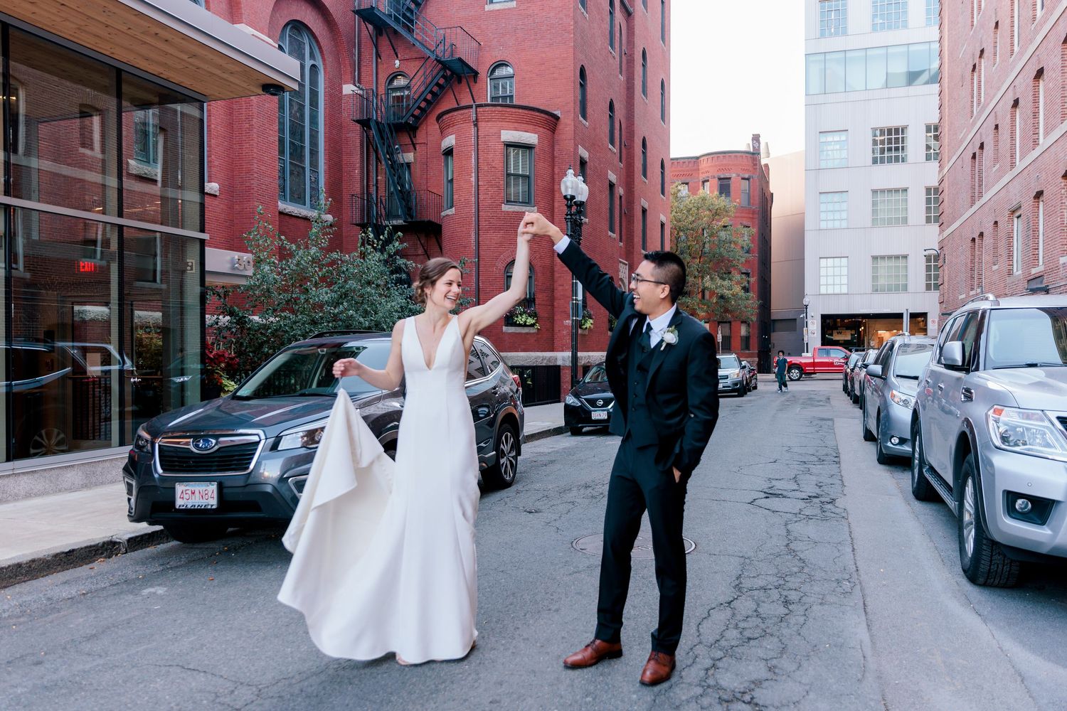 a city bride and groom dance in the street