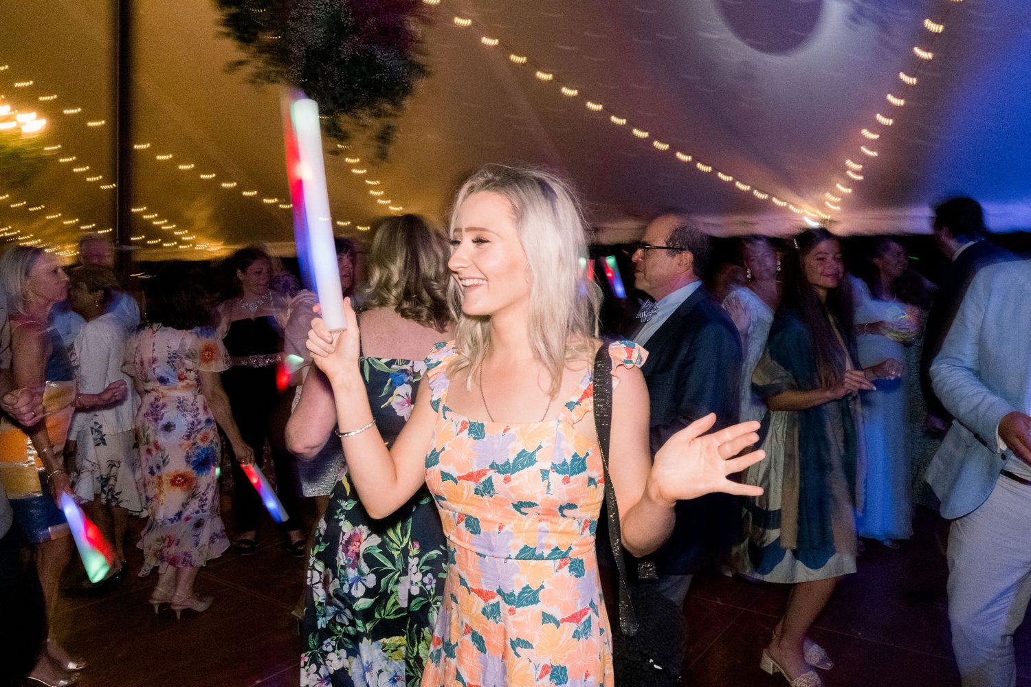 A candid photo of a wedding guest dancing at a backyard reception.