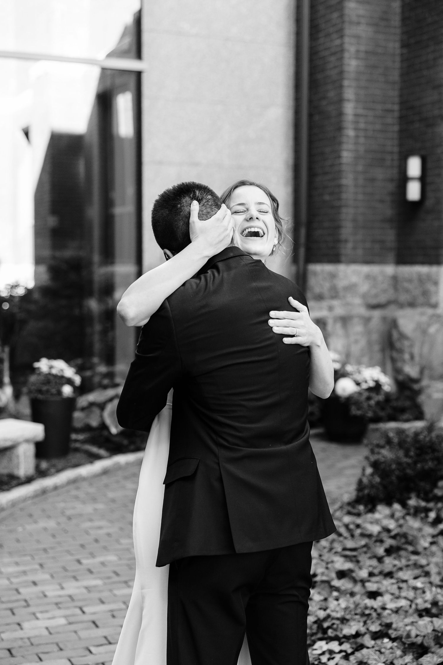 A candid photo of a bride smiling and holding her groom.