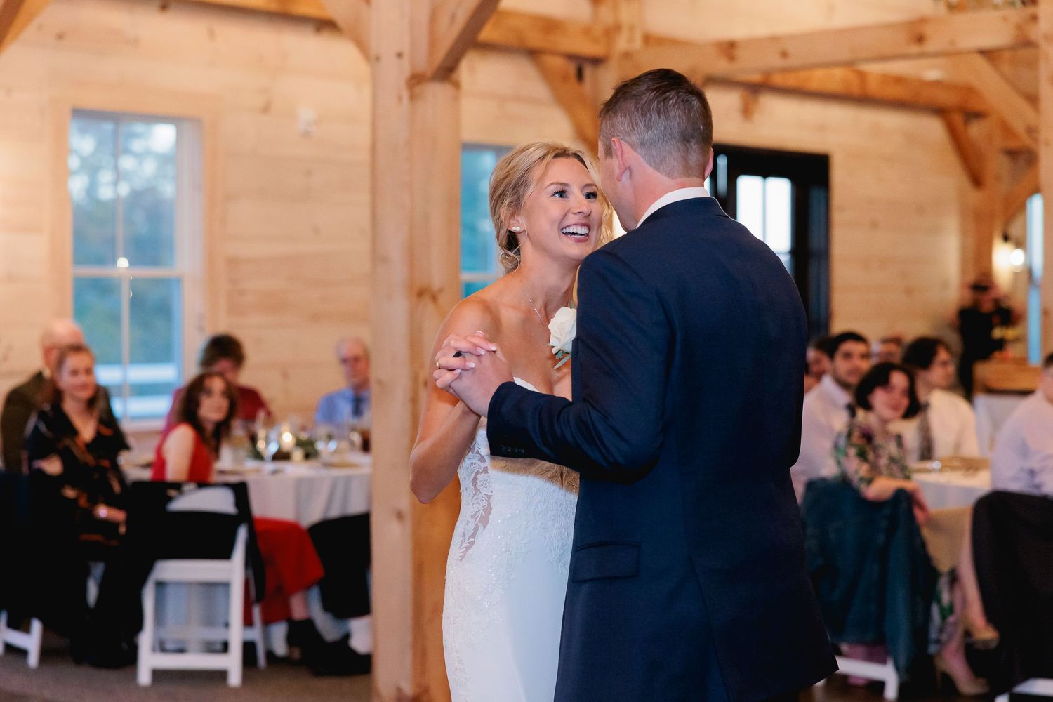 a bride and groom share their first dance in a barn wedding