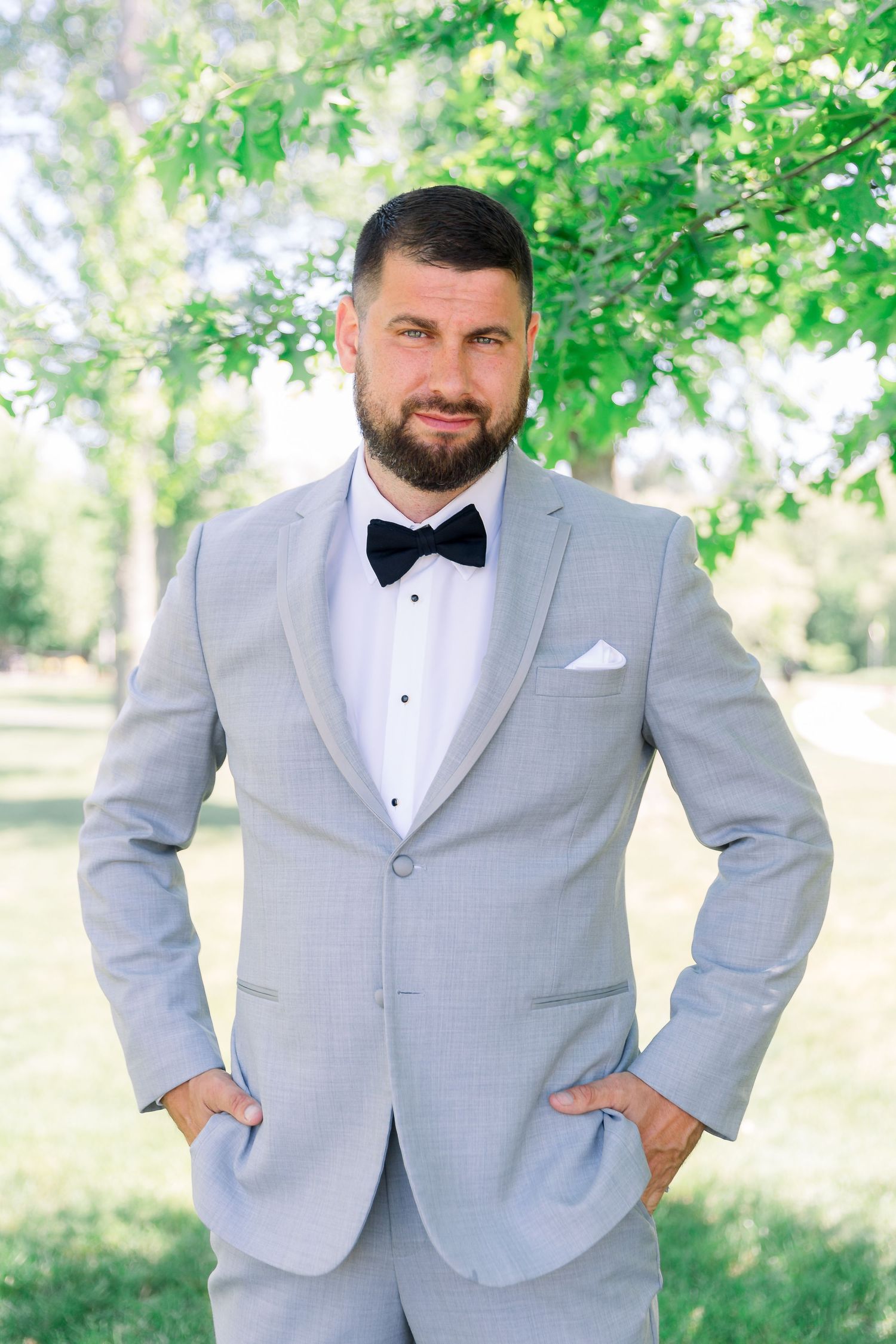 A portrait of the groom outside in a park.