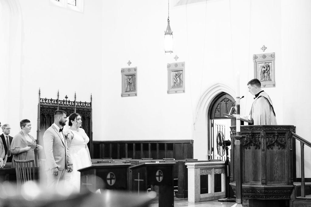 Black and white candid photo of a church ceremony for a bride and groom.