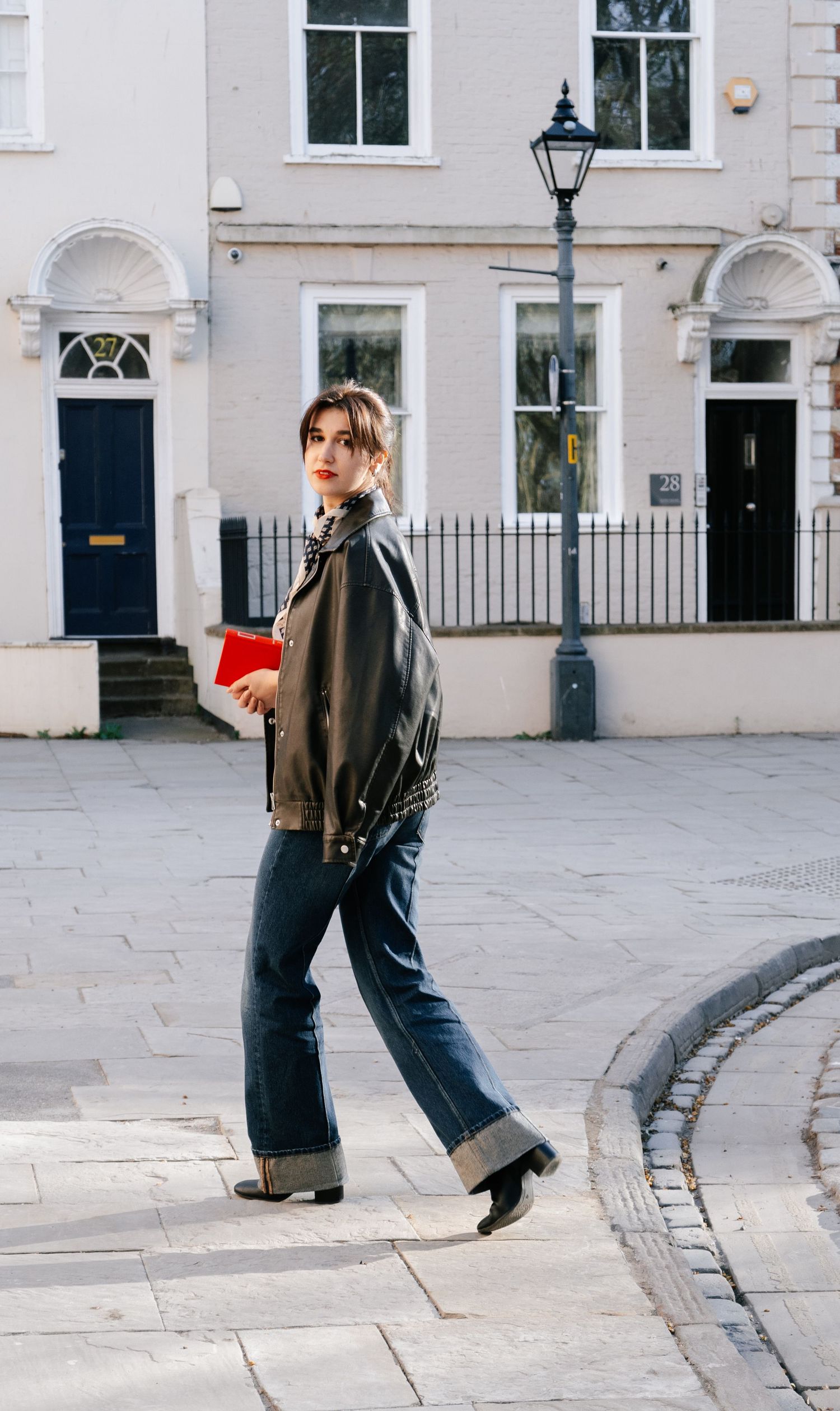 Casual street fashion poses in front of white Georgian townhouses with black iron railings.