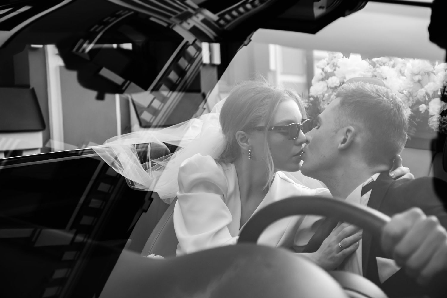 Black and white wedding photo of couple in car.
