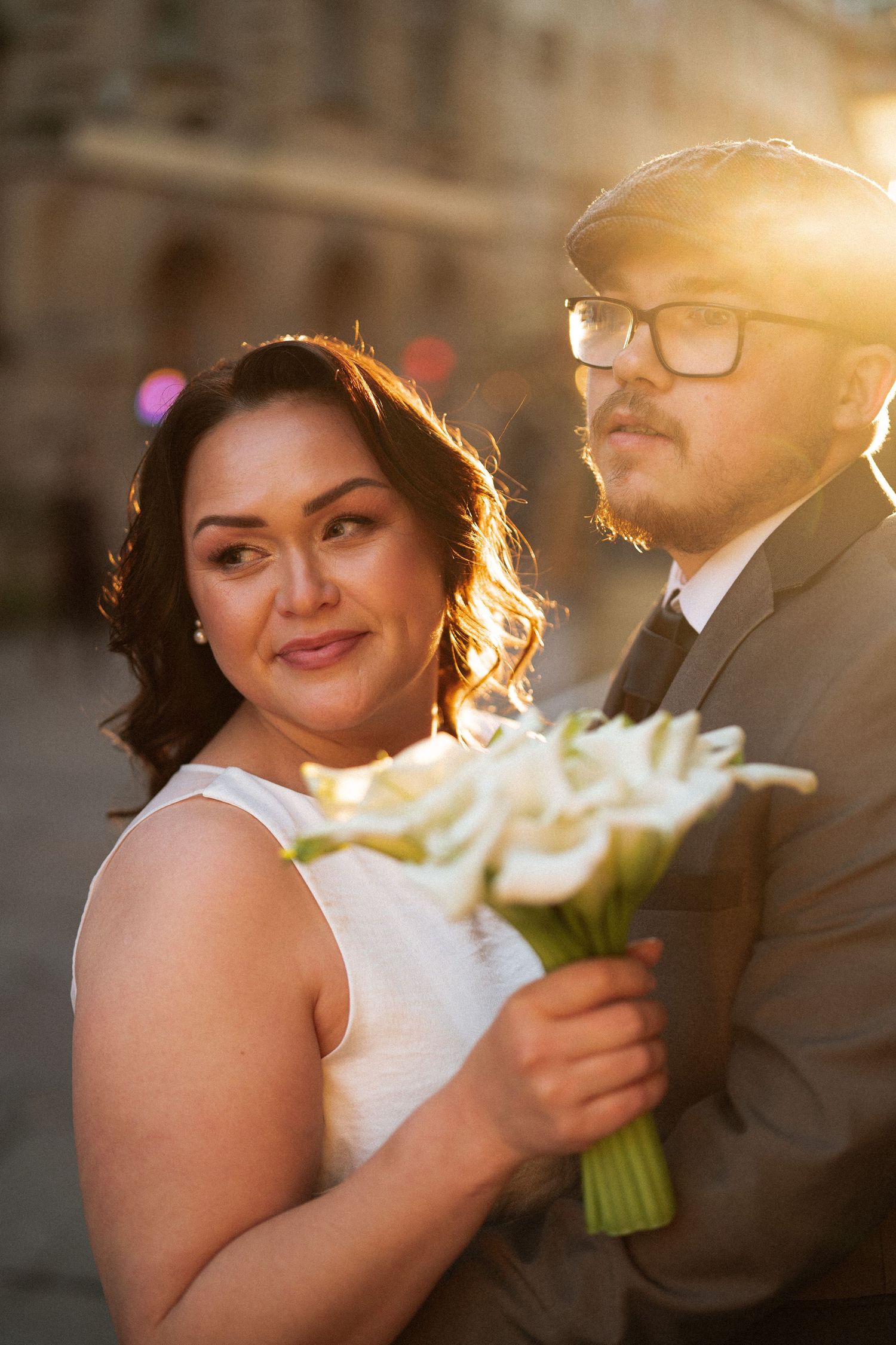 A romantic wedding photoshoot sequence showing a couple with a white calla lily bouquet in warm sunset lighting.
