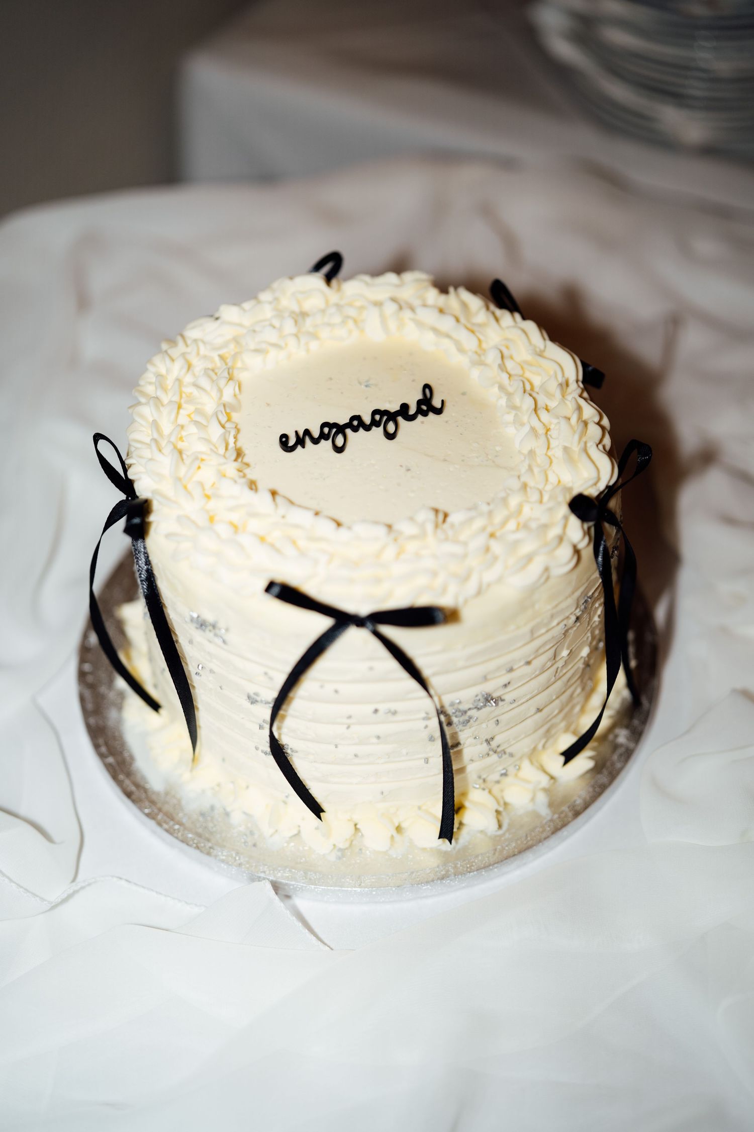 A sequence of photos showing a white frosted cake being decorated with black licorice pieces arranged in different patterns.