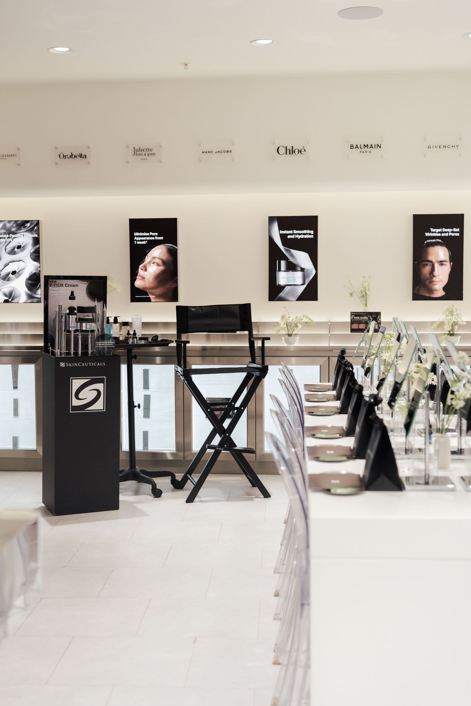 Luxury beauty store interior with makeup artist chair, skincare displays, and designer brand logos including Chloe and Balmain.