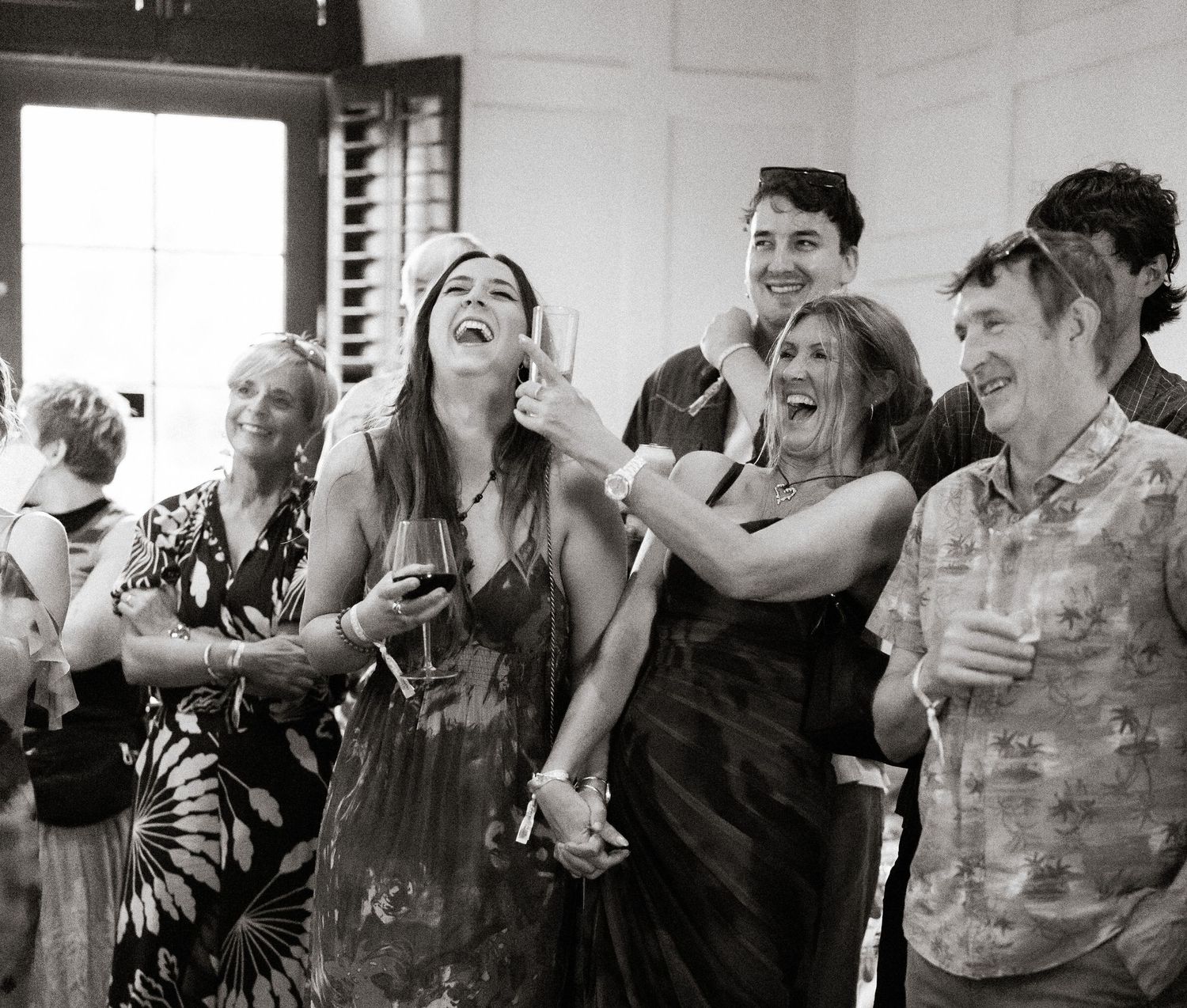 A black and white collage strip showing multiple people laughing and expressing joy in candid moments.