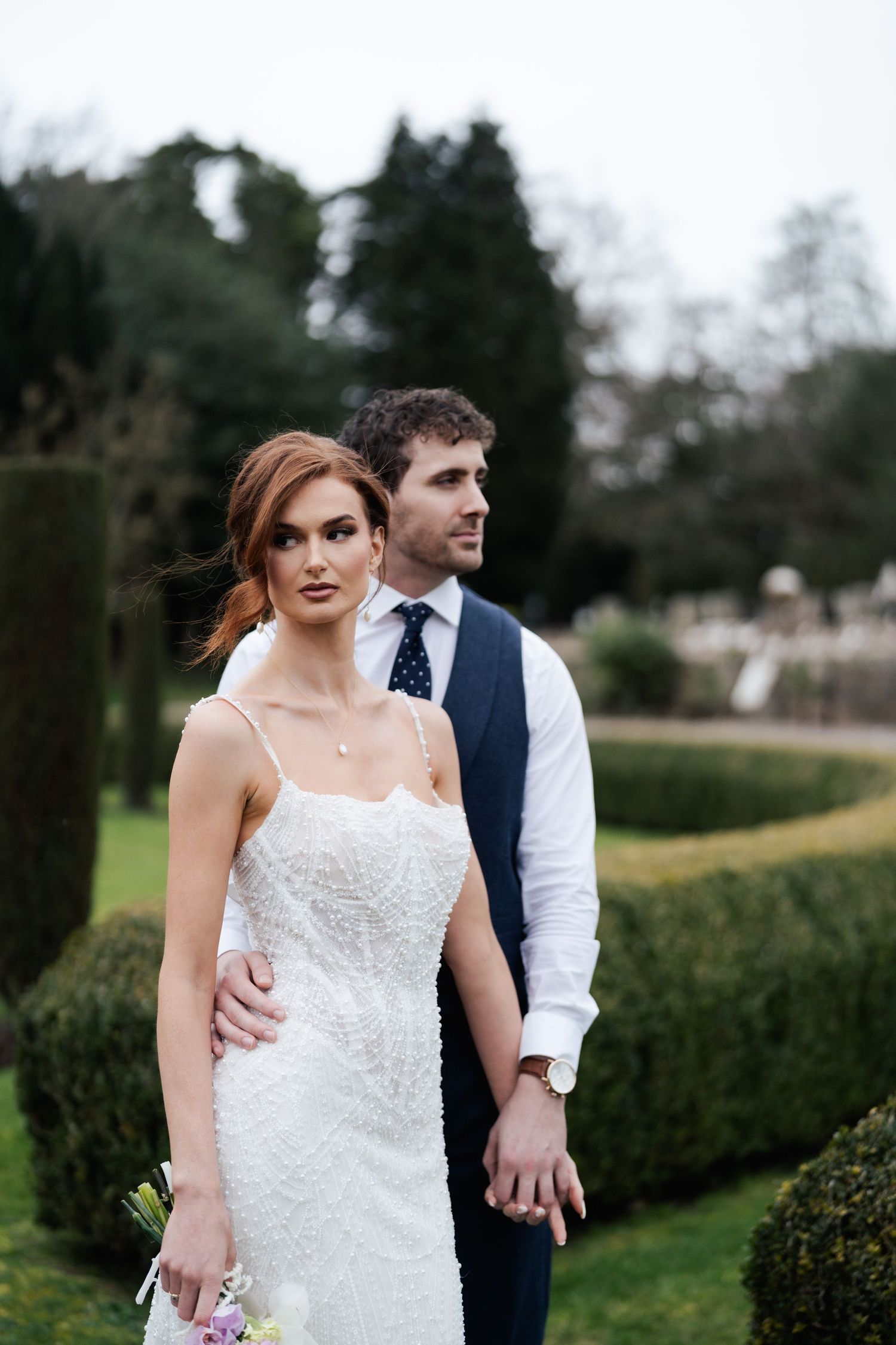 A romantic wedding photo series showing a couple in a garden setting with the bride in a white lace dress.