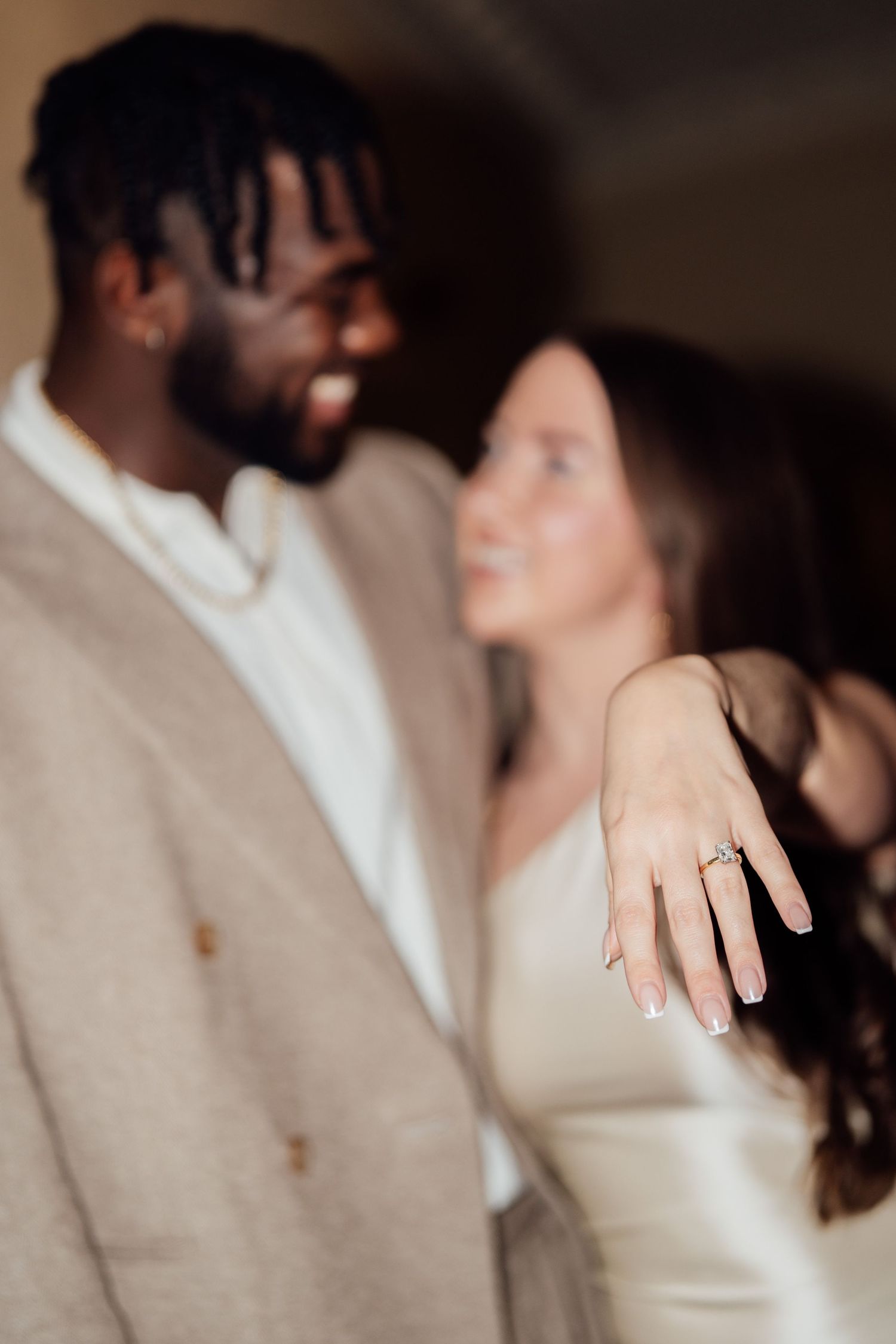 Close-up detail of a couple's hands showing an engagement ring in a romantic wedding moment.