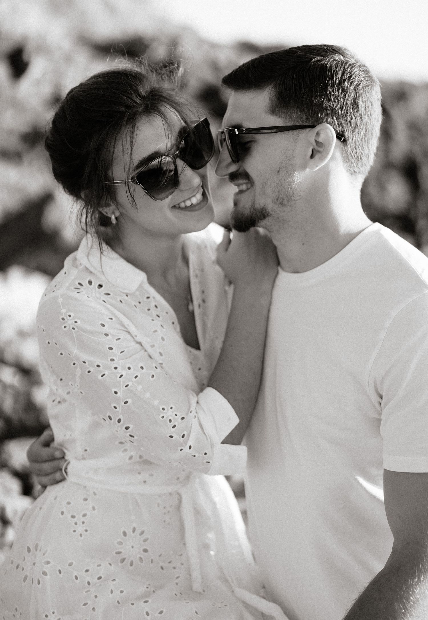 Intimate black and white portrait of a couple in white clothing.