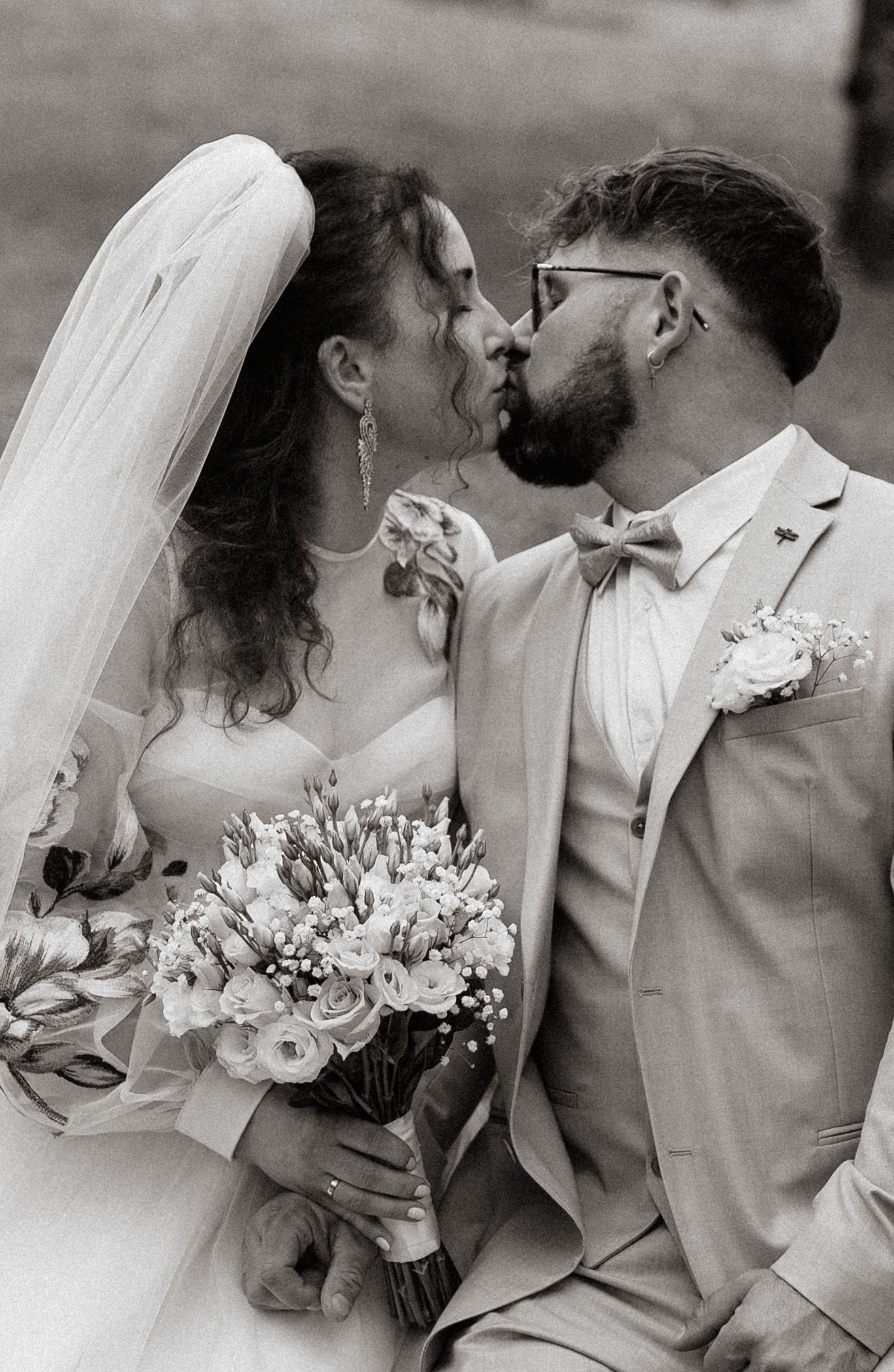 A black and white photo sequence showing a romantic wedding kiss with a bridal bouquet of white flowers.