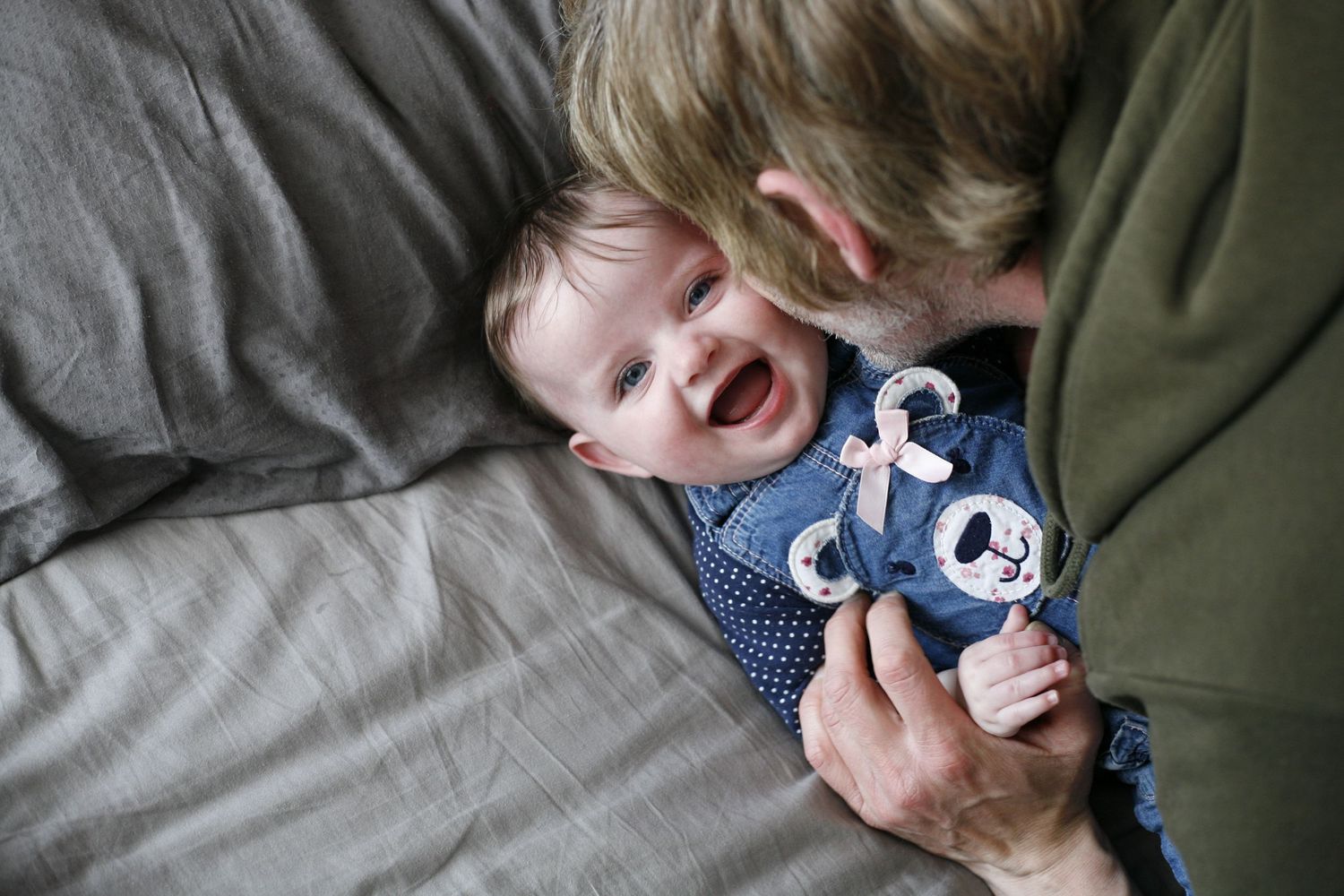 playful image of a laughing child and adult  on a grey background
