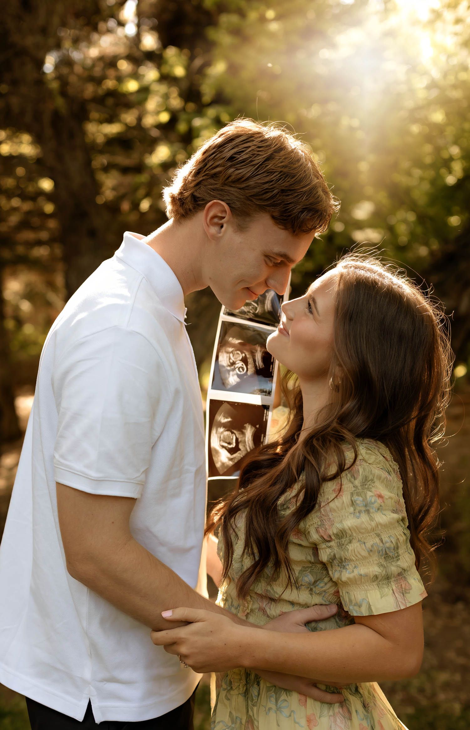 couple nose to nose doing announcement pictures ion ogden Utah at botanical gardens
