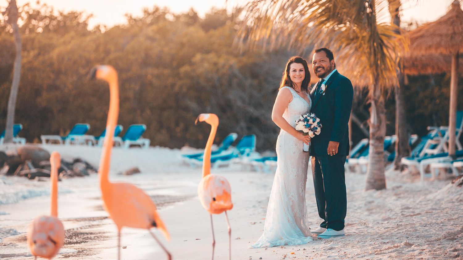Beach wedding photography session during golden hour with palm trees.