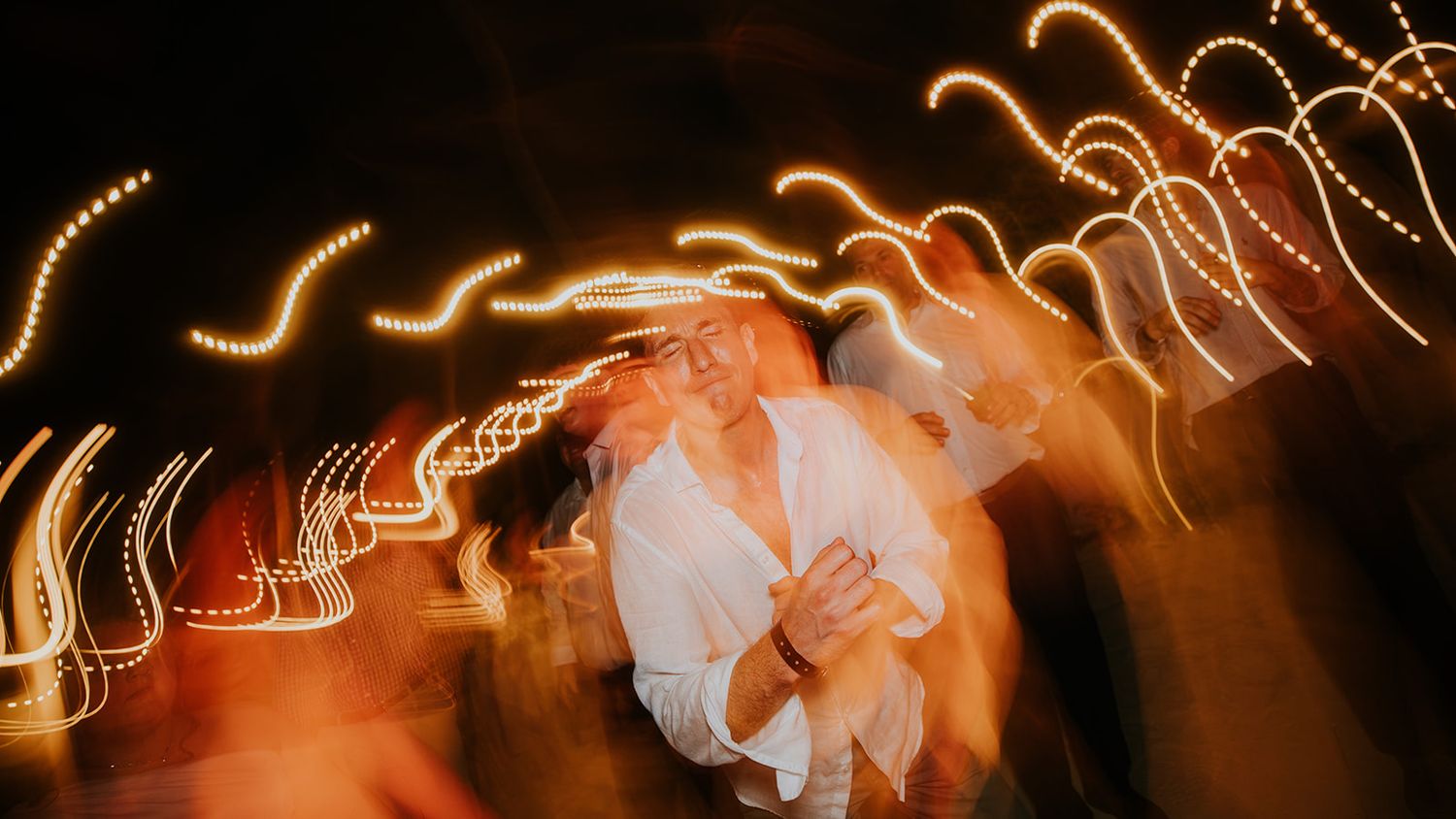 Long exposure wedding photo with light trails creating magical streaks of motion.