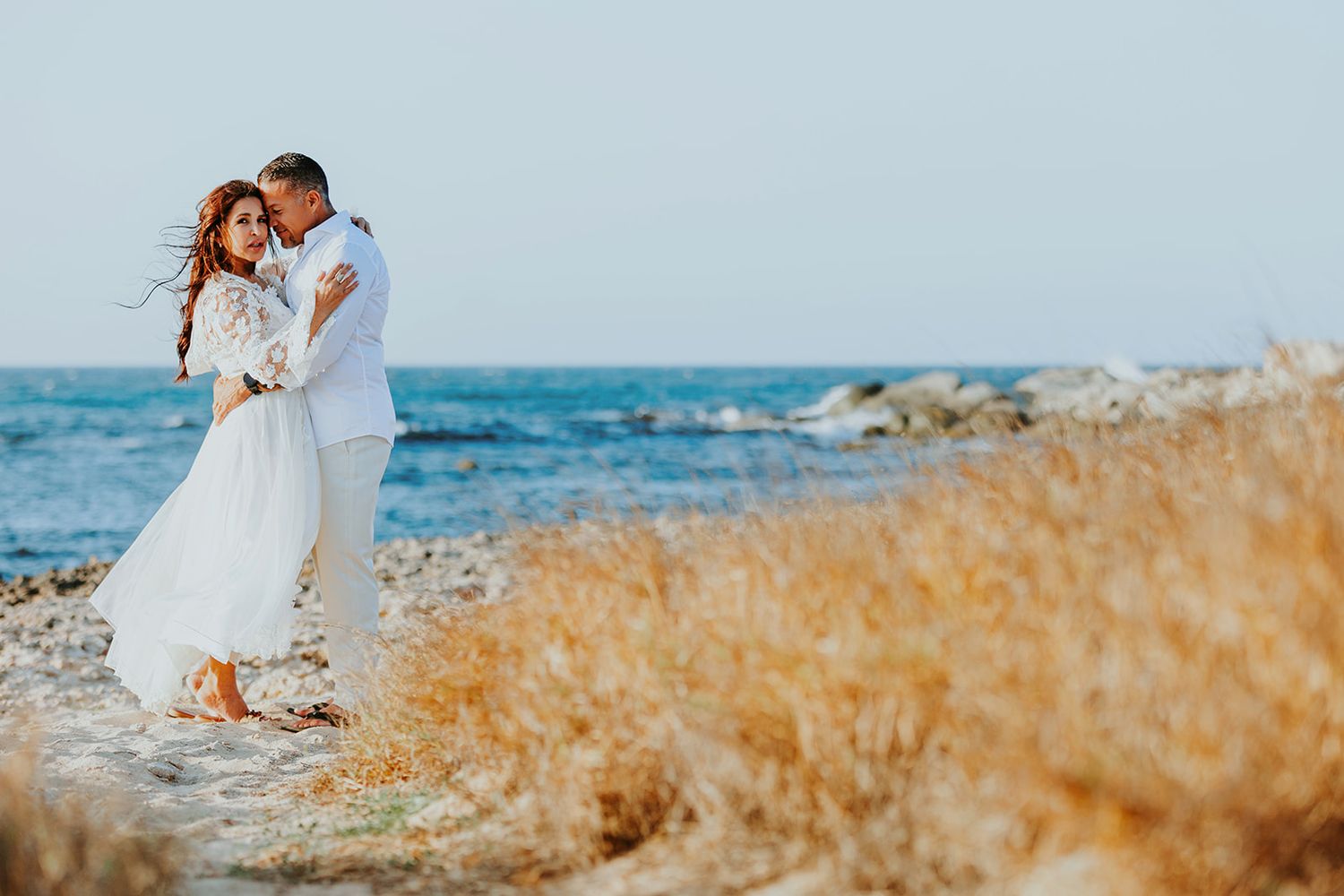 Couple embracing on Aruba beach with turquoise ocean in the background