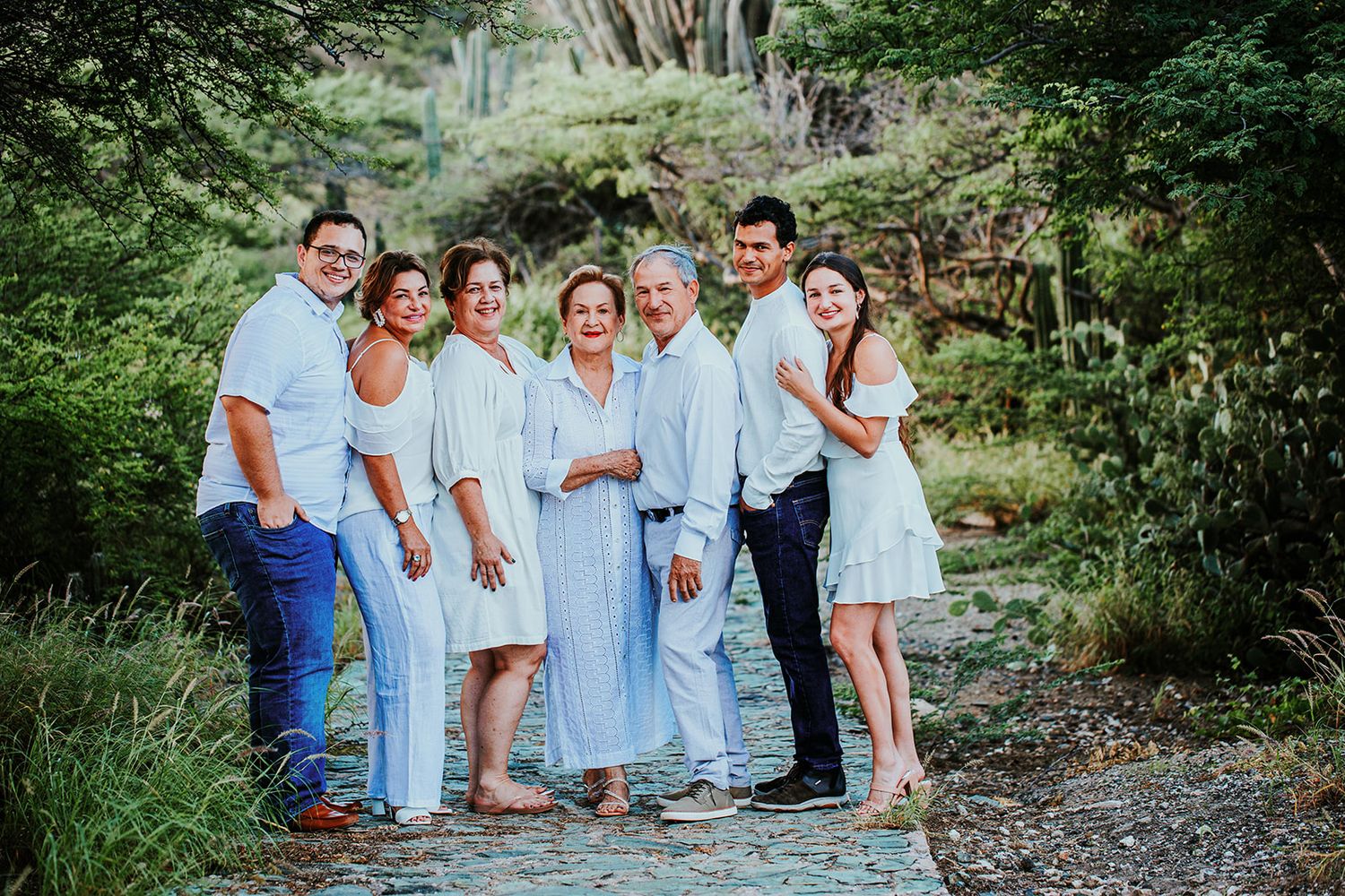 Group photo of loved ones wearing coordinating blue and white outfits in a natural outdoor setting.