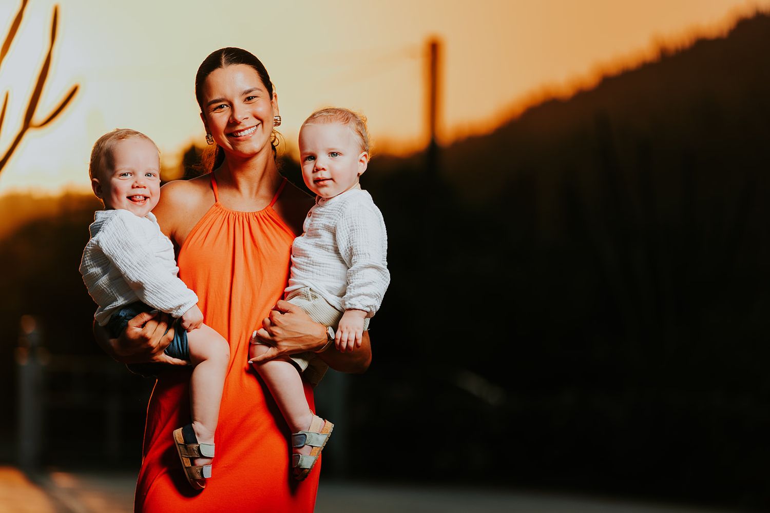Family members pose together during golden hour against a dark mountain backdrop.