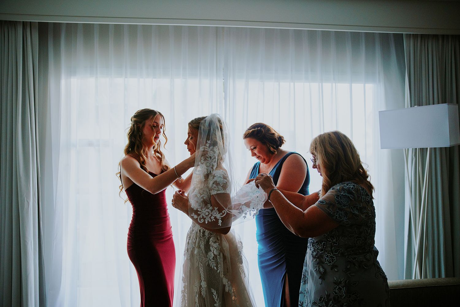 Silhouettes of people in a room with curtains and dramatic lighting creating a moody atmosphere.