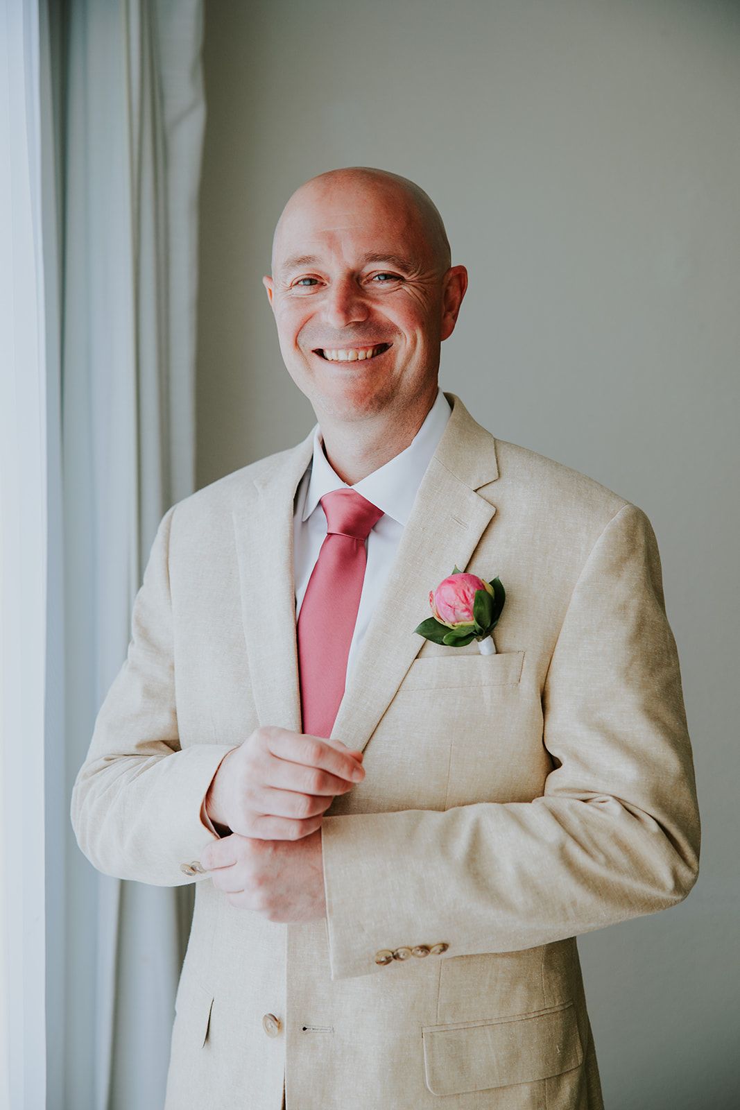 Wedding attire features a light beige suit paired with a coral pink tie and boutonniere in three similar poses.