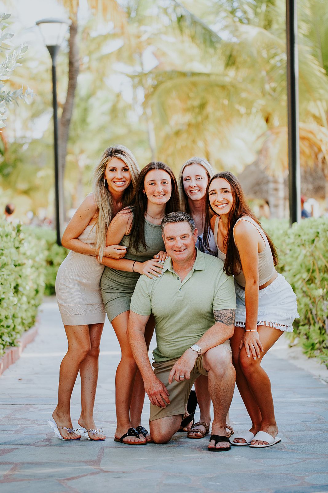 Group poses playfully together on a pathway surrounded by lush tropical foliage.