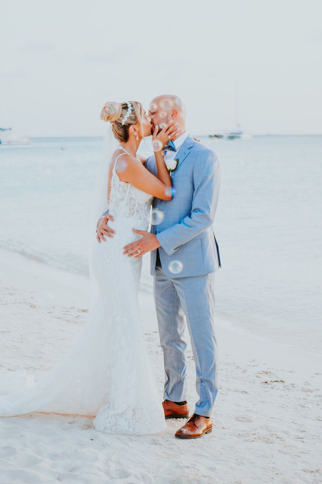 Romantic beach wedding portrait with light blue sky background.