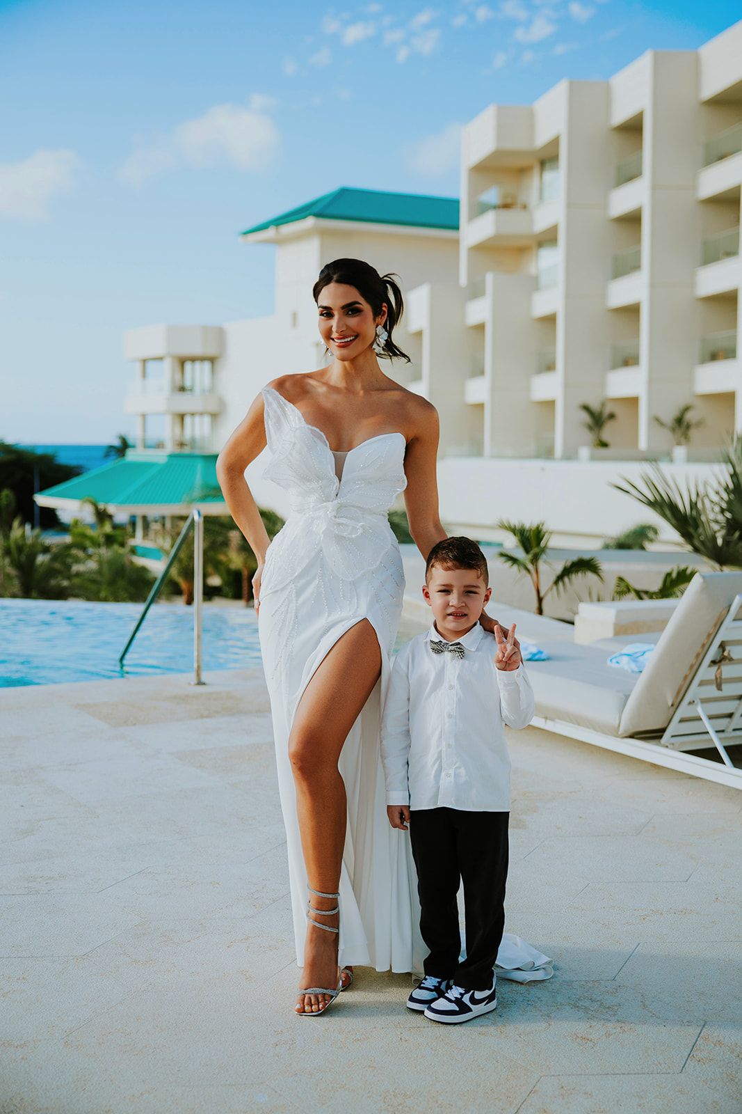 A wedding photo series showing a mother and son in formal attire posing together by a resort pool area.