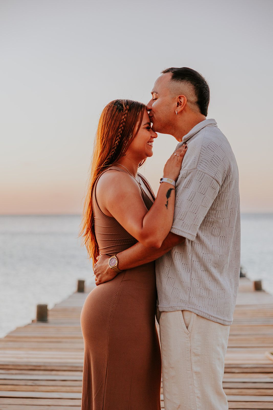 Romantic Aruba sunset engagement photo on wooden pier by the ocean.