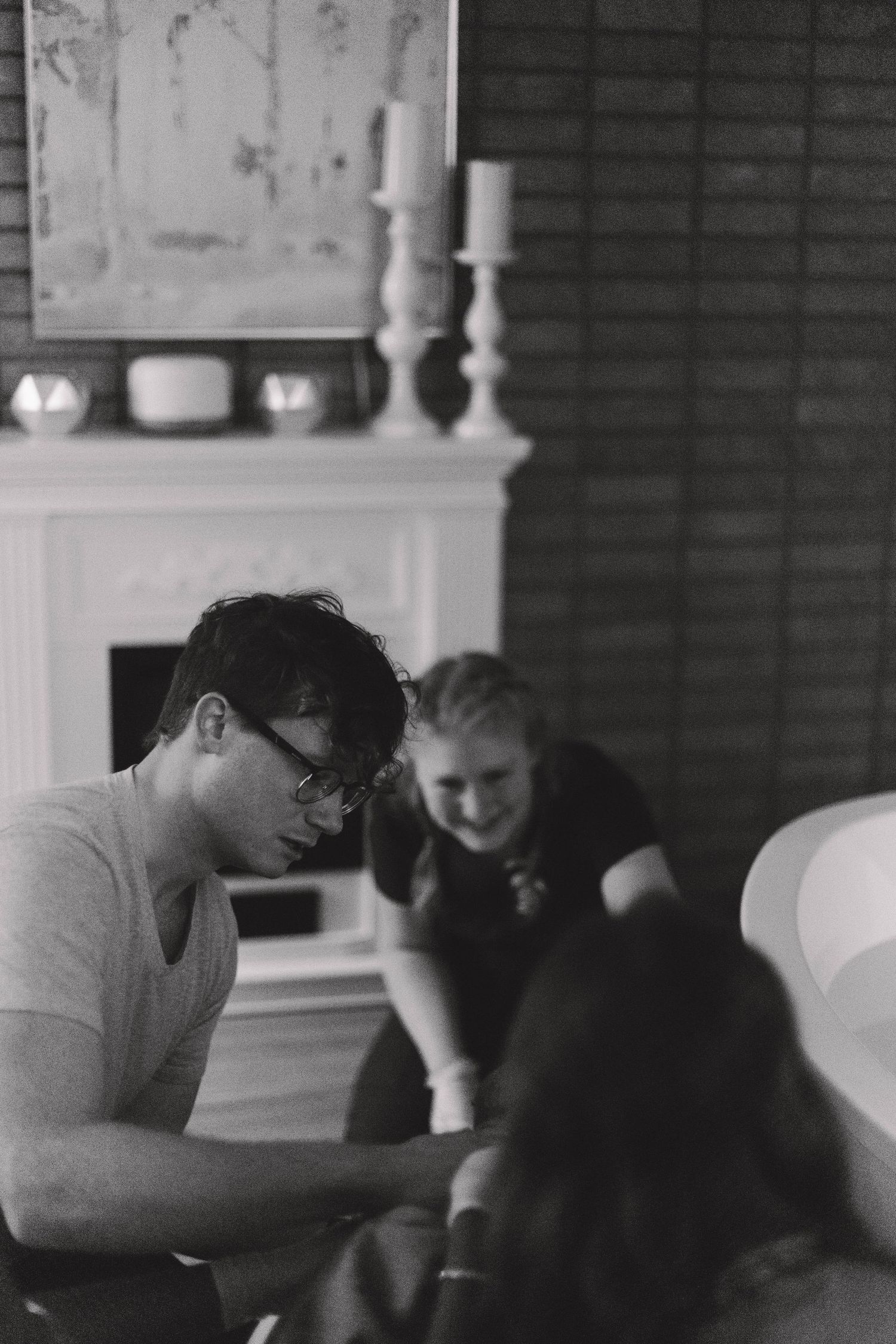 Black and white image of a birth partner and doula supporting a laboring woman at home.