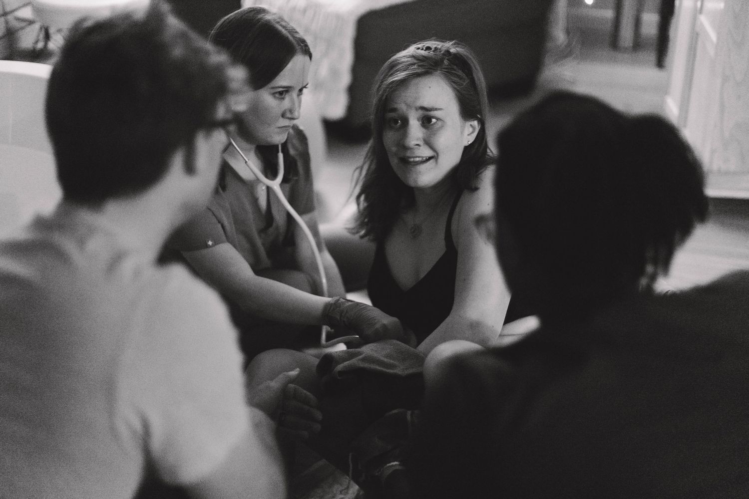 Black and white photo of a group of women sitting together in an intimate supportive discussion circle.