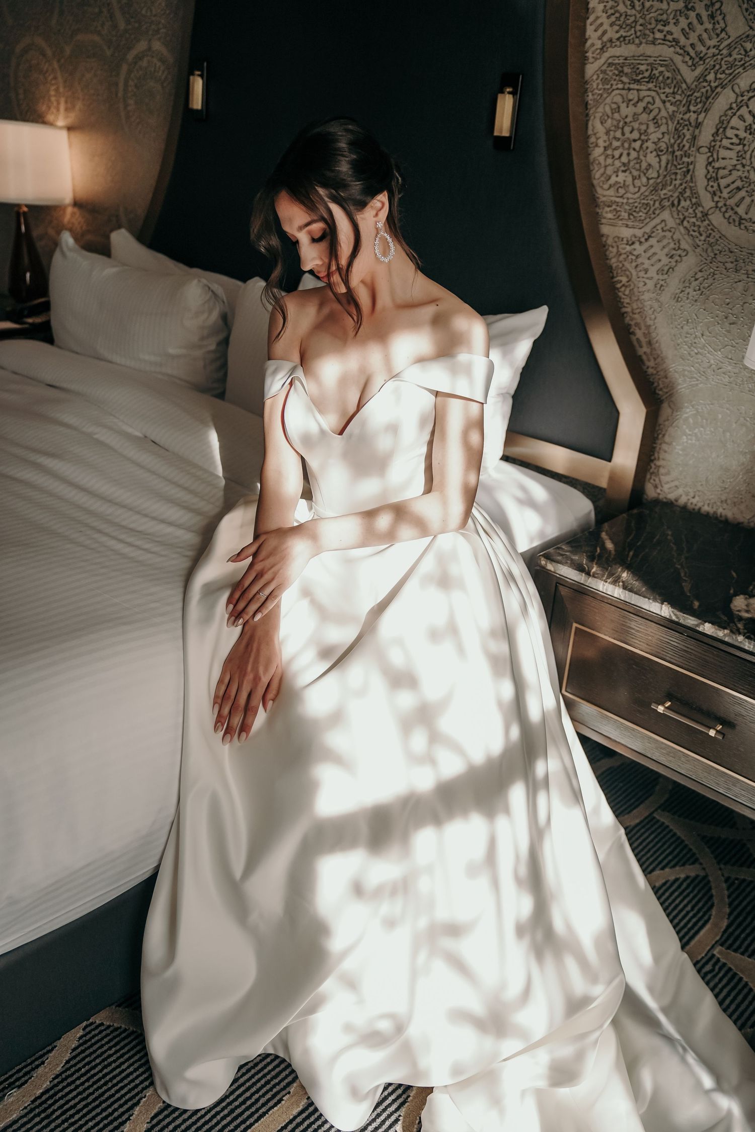 Elegant white wedding dress details captured in natural window light.