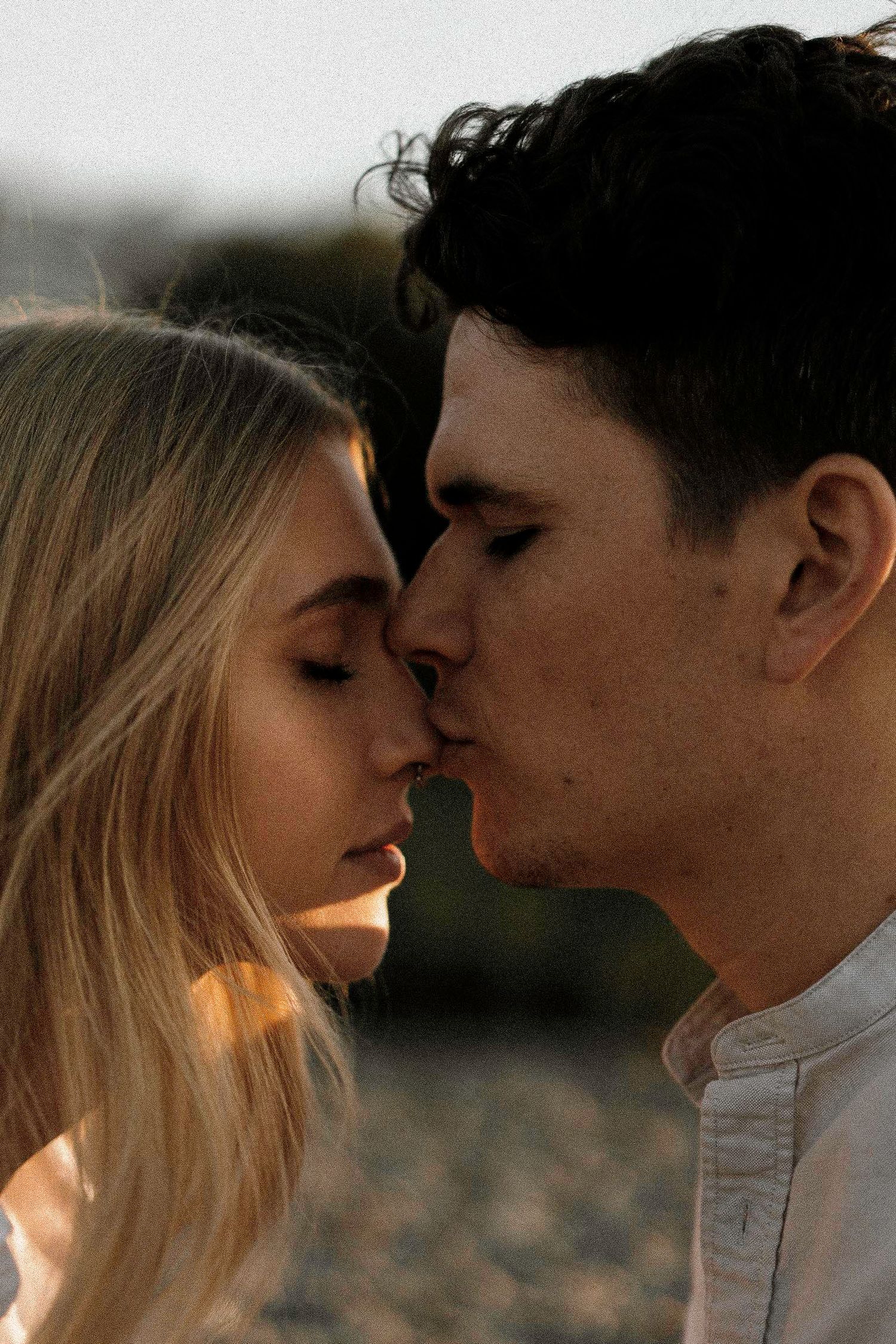 Intimate close-up portrait of couple in warm sunset lighting.