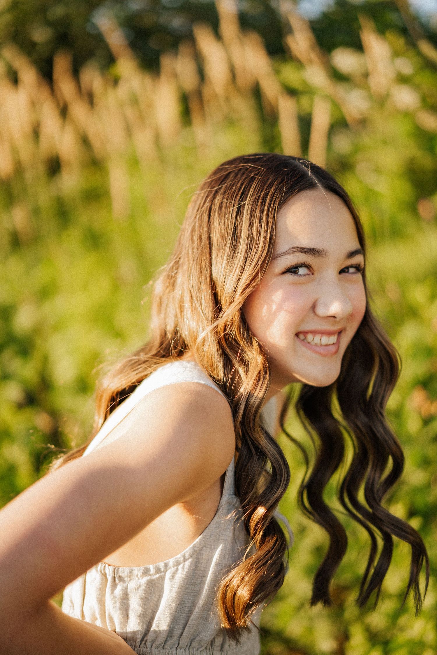 Portrait shot in golden sunlight with natural foliage backdrop.