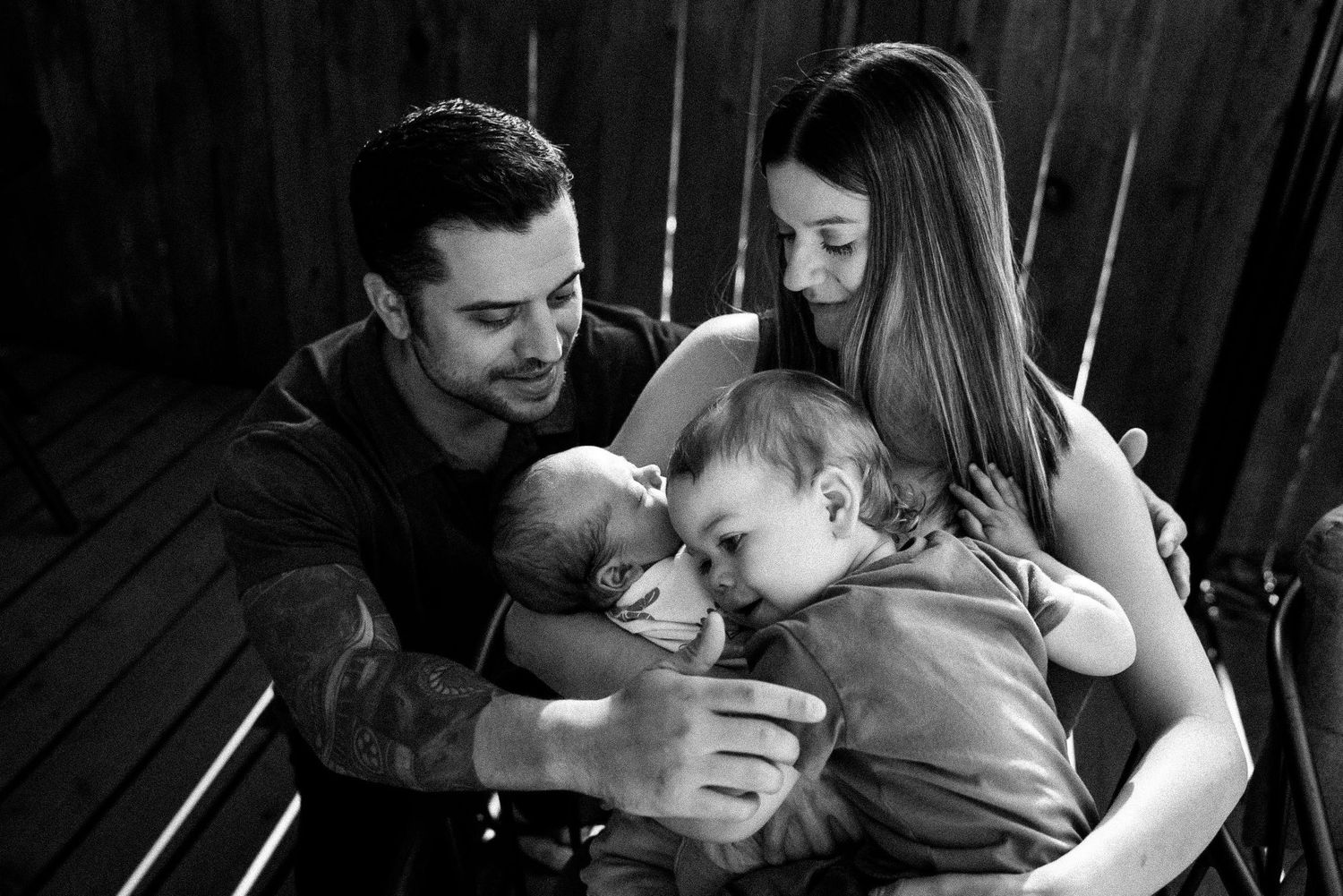 A series of black and white candid family photos showing tender moments between parents and children.