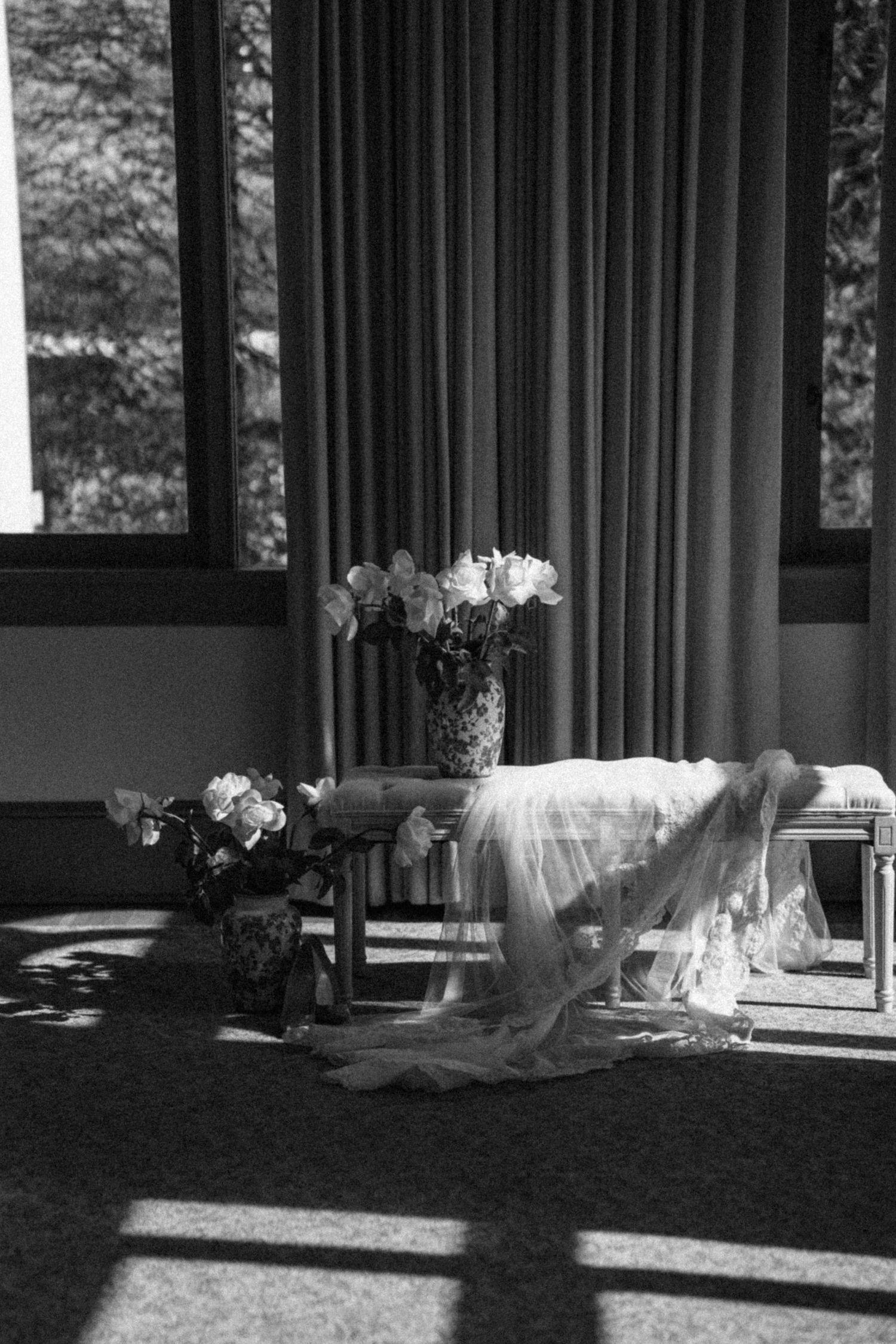 Sunlight streams through windows onto white draped tables in an elegant room.
