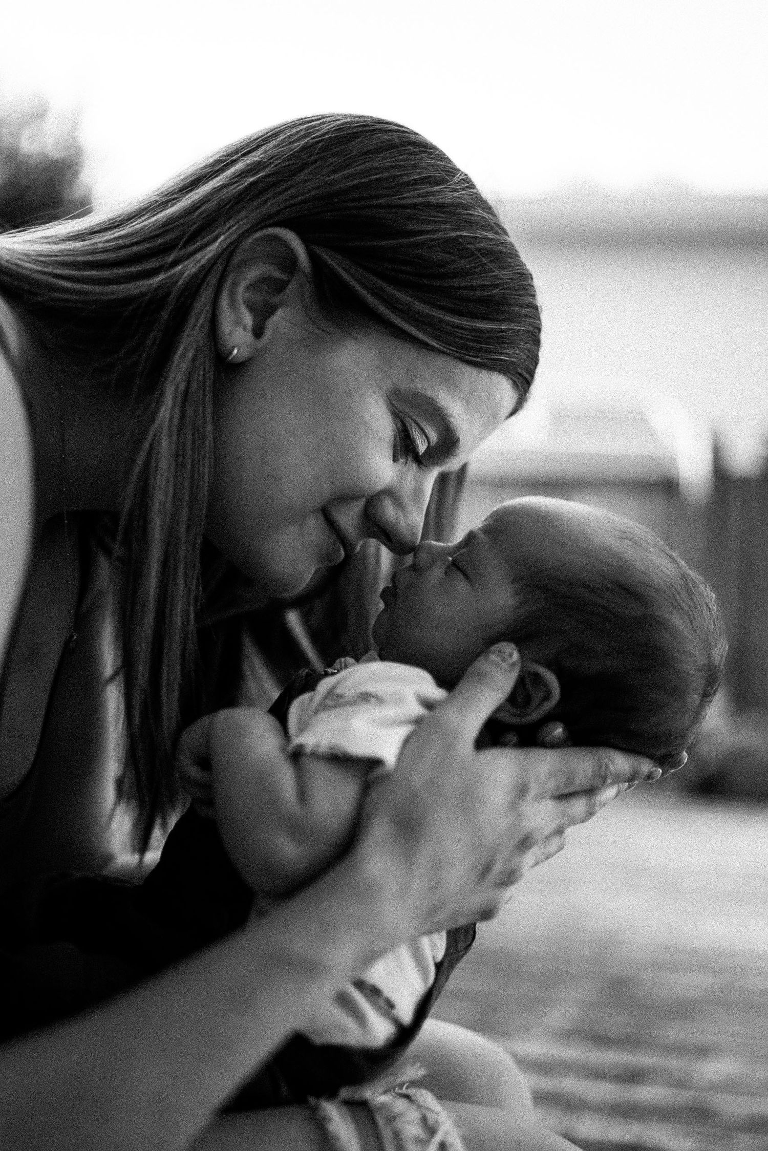 A series of black and white photos showing intimate moments between a mother and baby in close-up profile views.