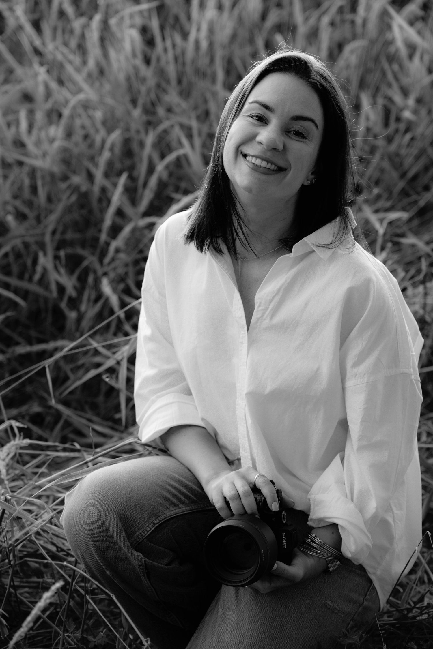 Black and white portrait sequence showing joyful expressions against a natural grass backdrop.