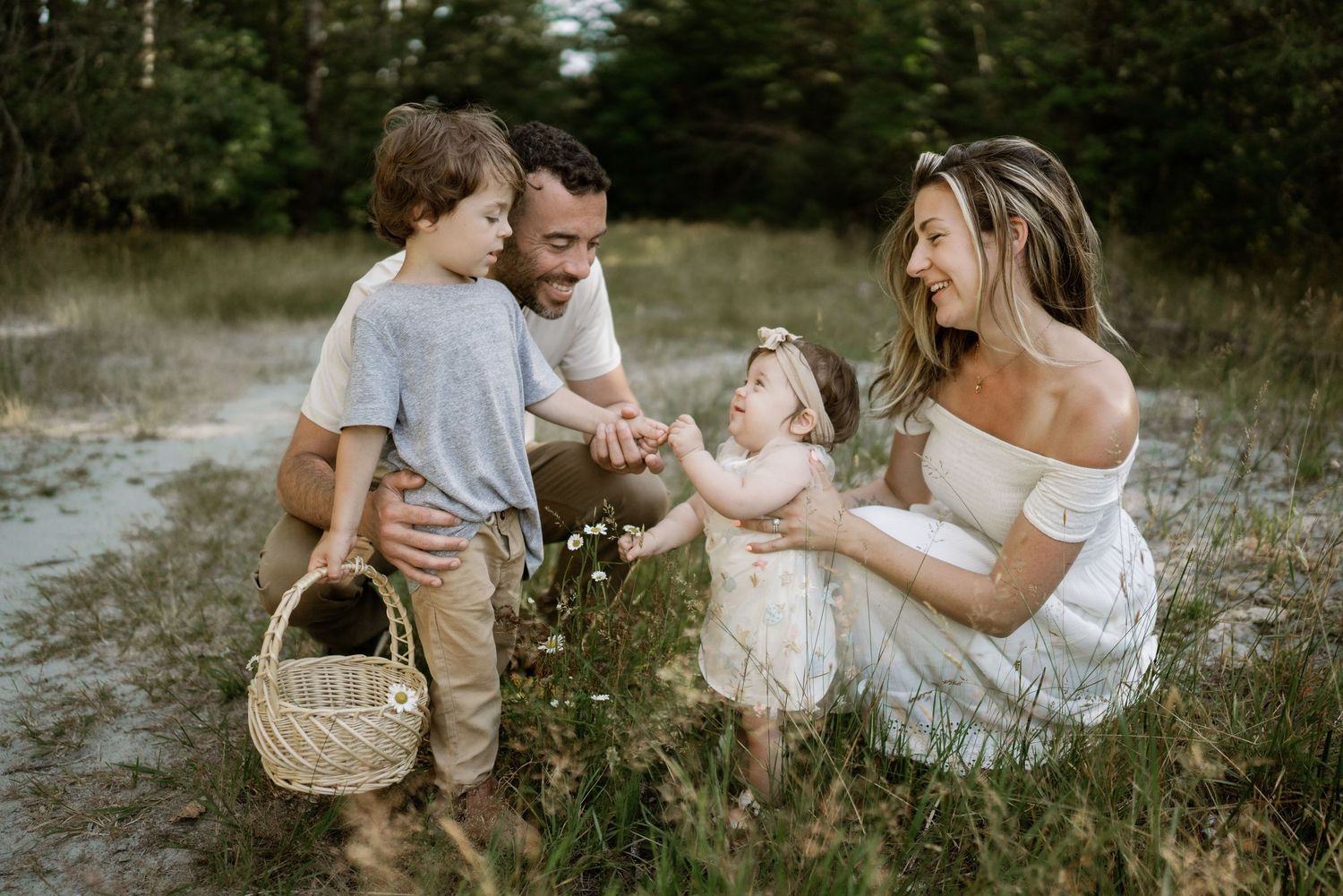 Family lounging together outdoors in a natural setting during golden hour.