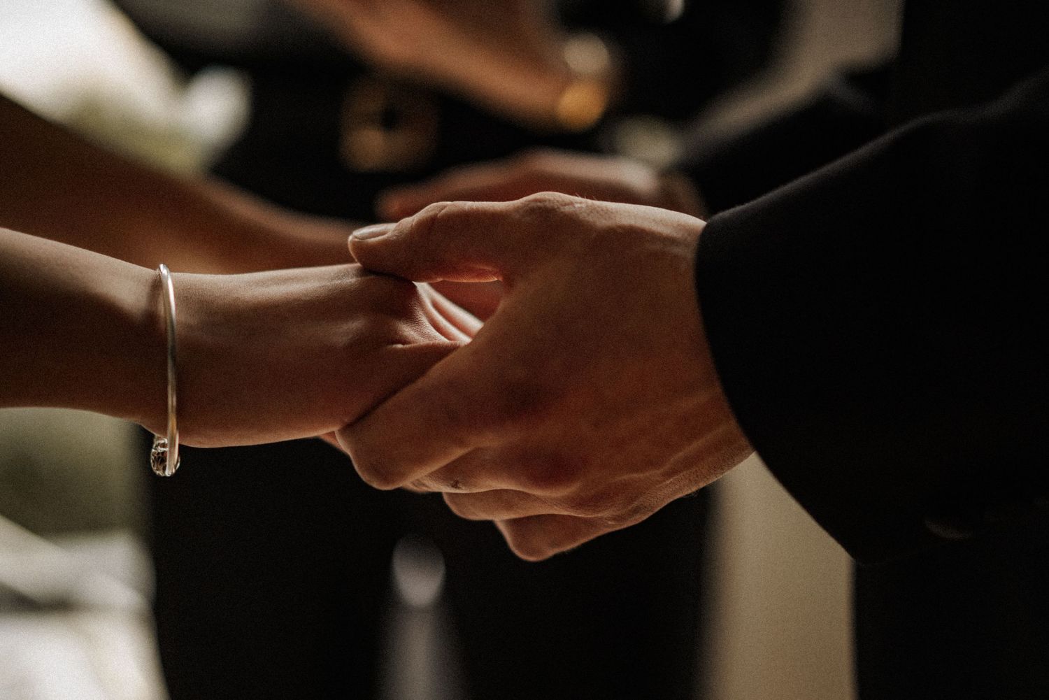 Close-up of hands exchanging rings during a wedding ceremony.