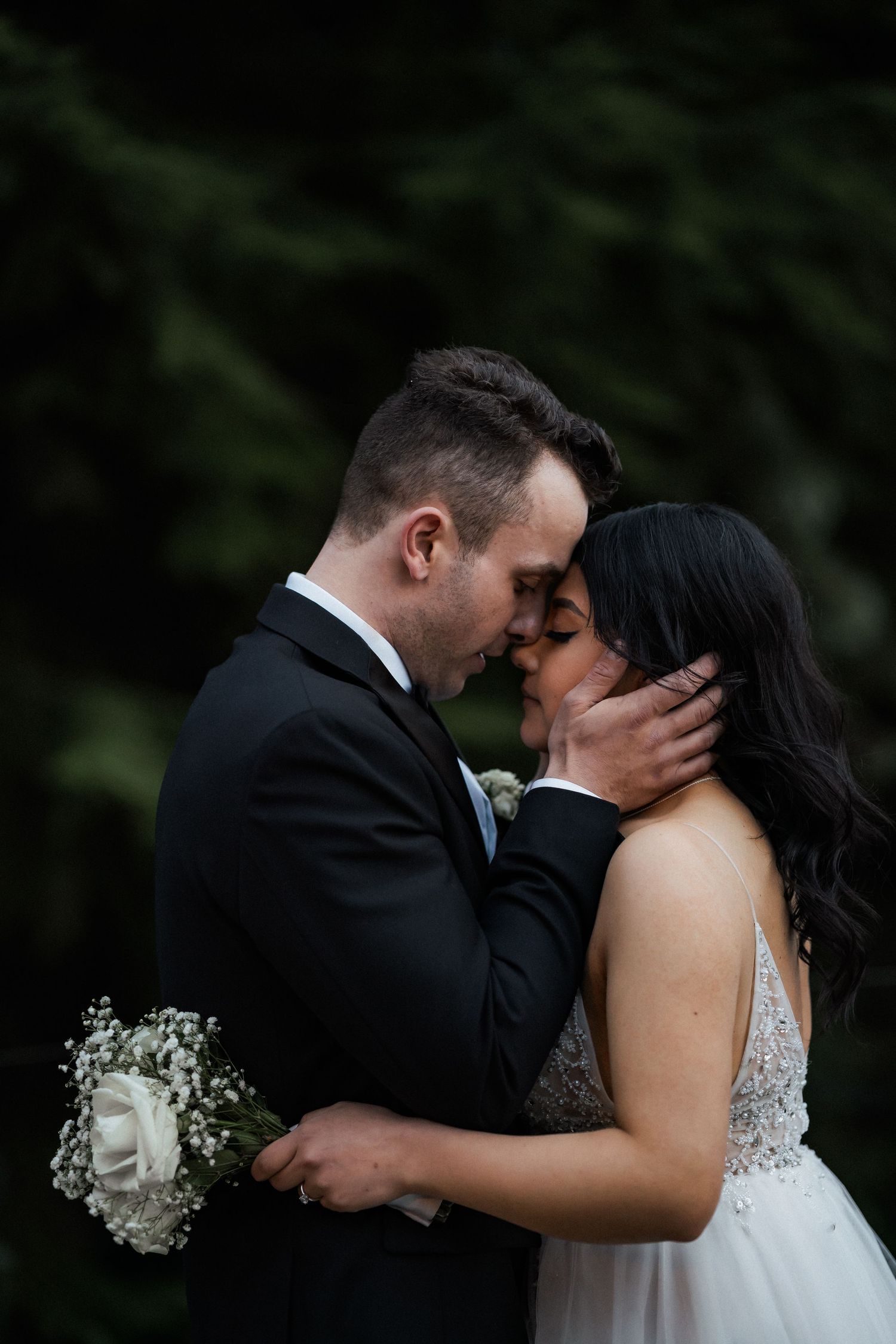 Intimate wedding portraits in a garden setting with baby's breath flowers and romantic poses.
