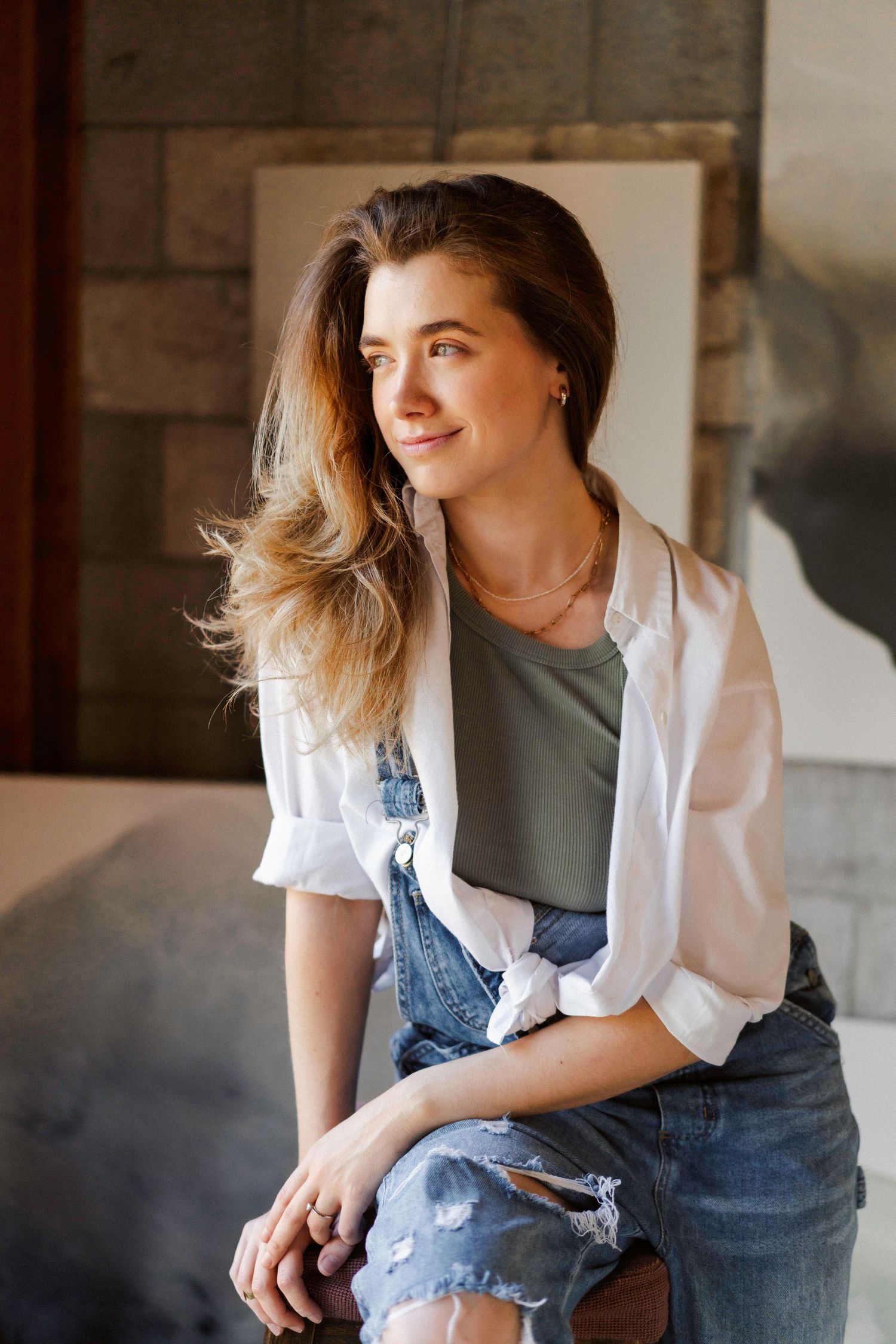 Casual portrait session in denim against rustic wooden wall.