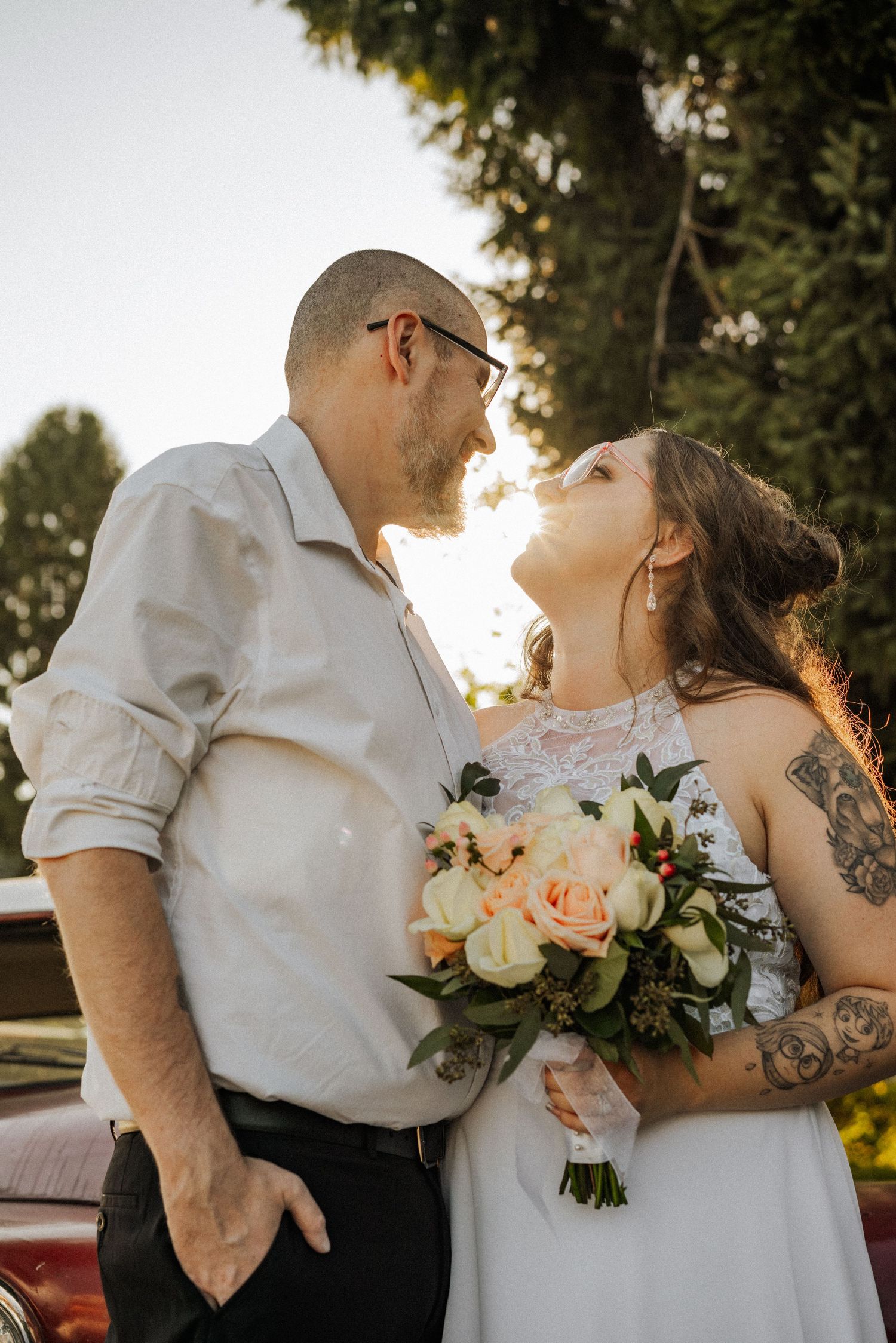 A romantic sunset wedding portrait with soft lighting and floral bouquet.