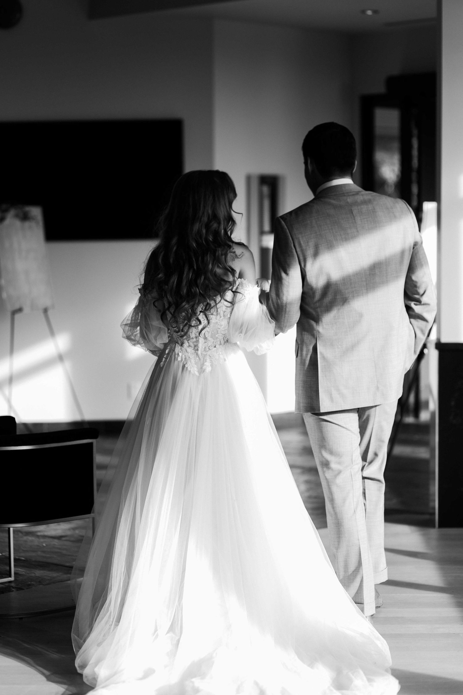 Black and white photos showing the silhouette of a wedding dress in a minimalist interior hallway.