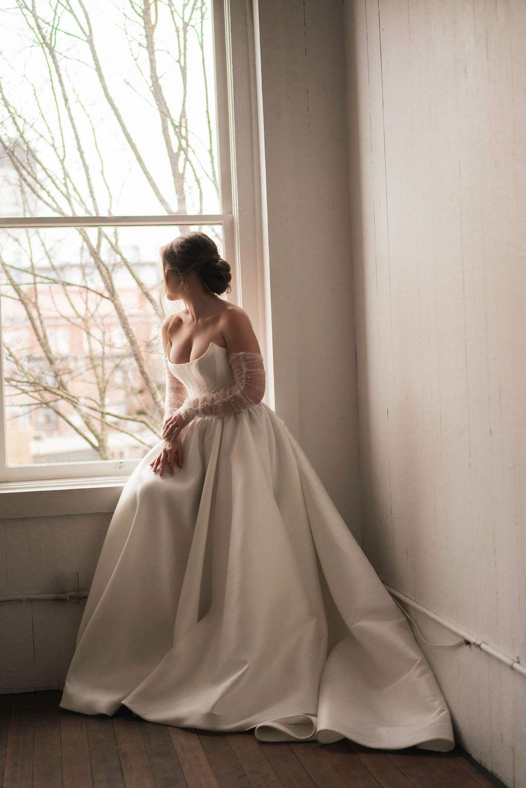 Artistic bridal portraits taken in a bright room with large windows and natural lighting.