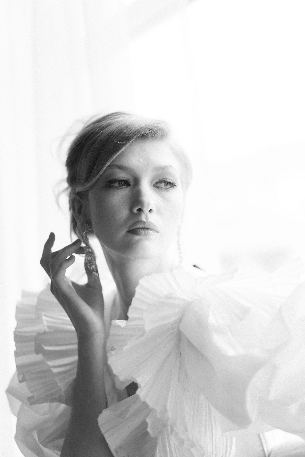 Artistic black and white portrait featuring ethereal white ruffled fabric details.