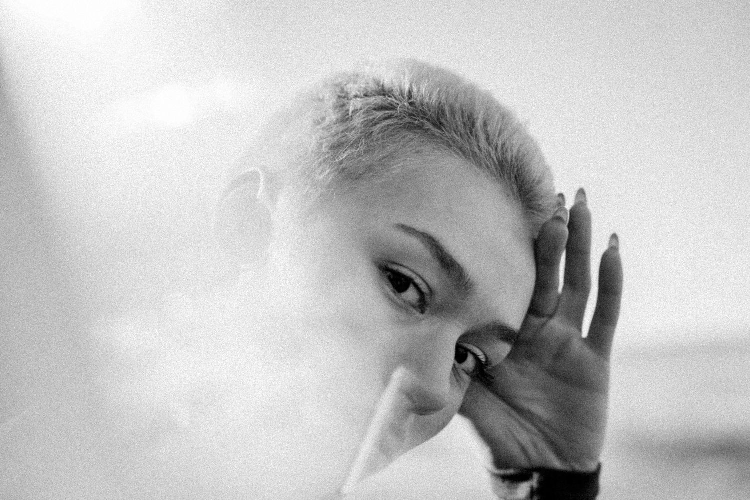 Black and white portrait series showing a person's face with dramatic shadows and expressive hand gestures.