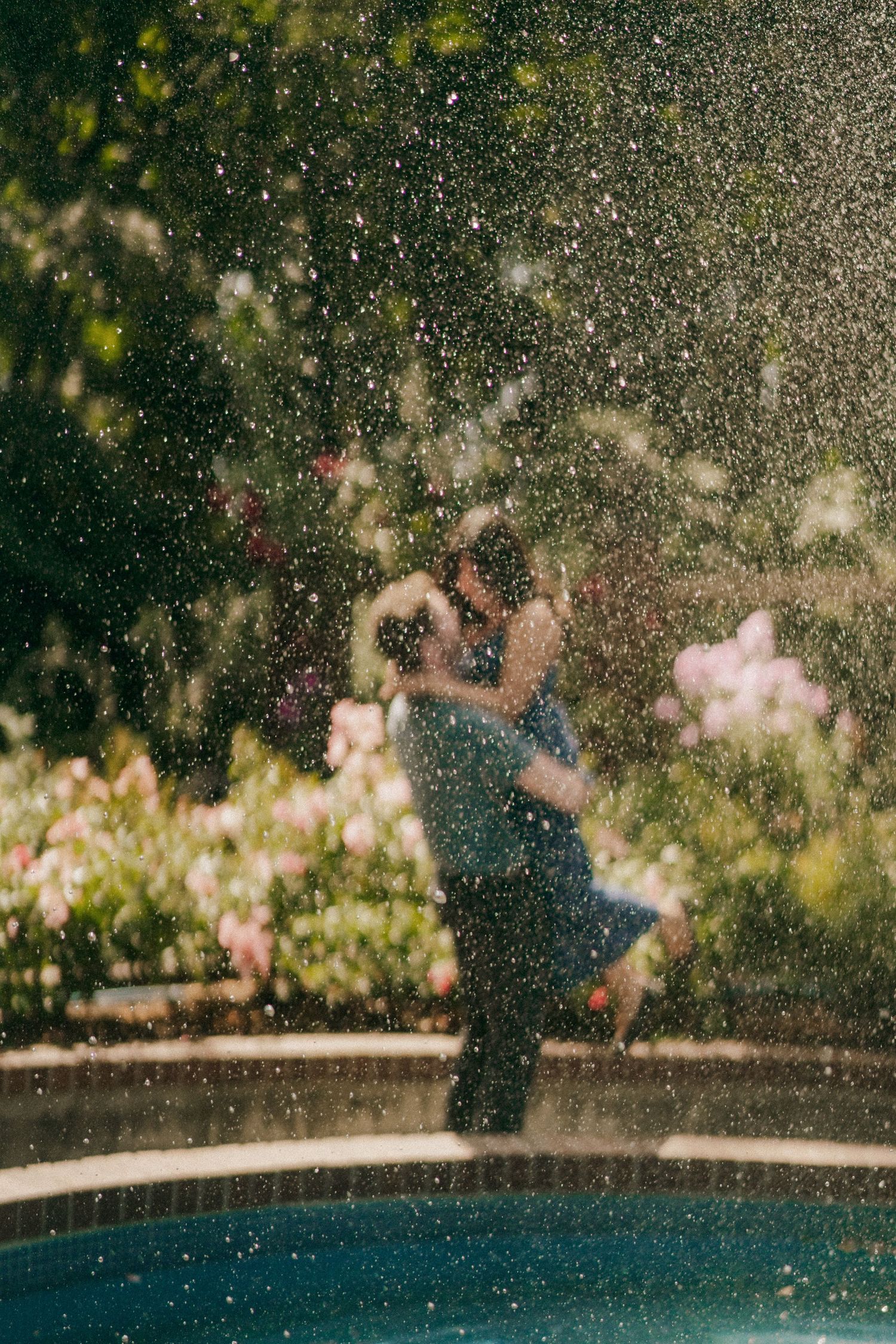 Dreamy poolside scene with water droplets and bokeh lighting effects.